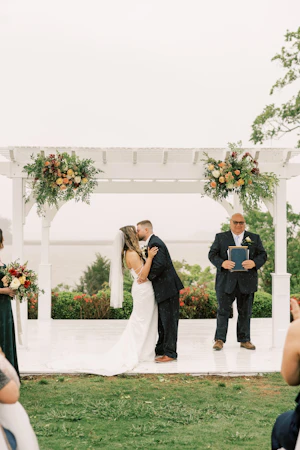 Bride wearing Clover by Rebecca Ingram kissing her husband during their ceremony