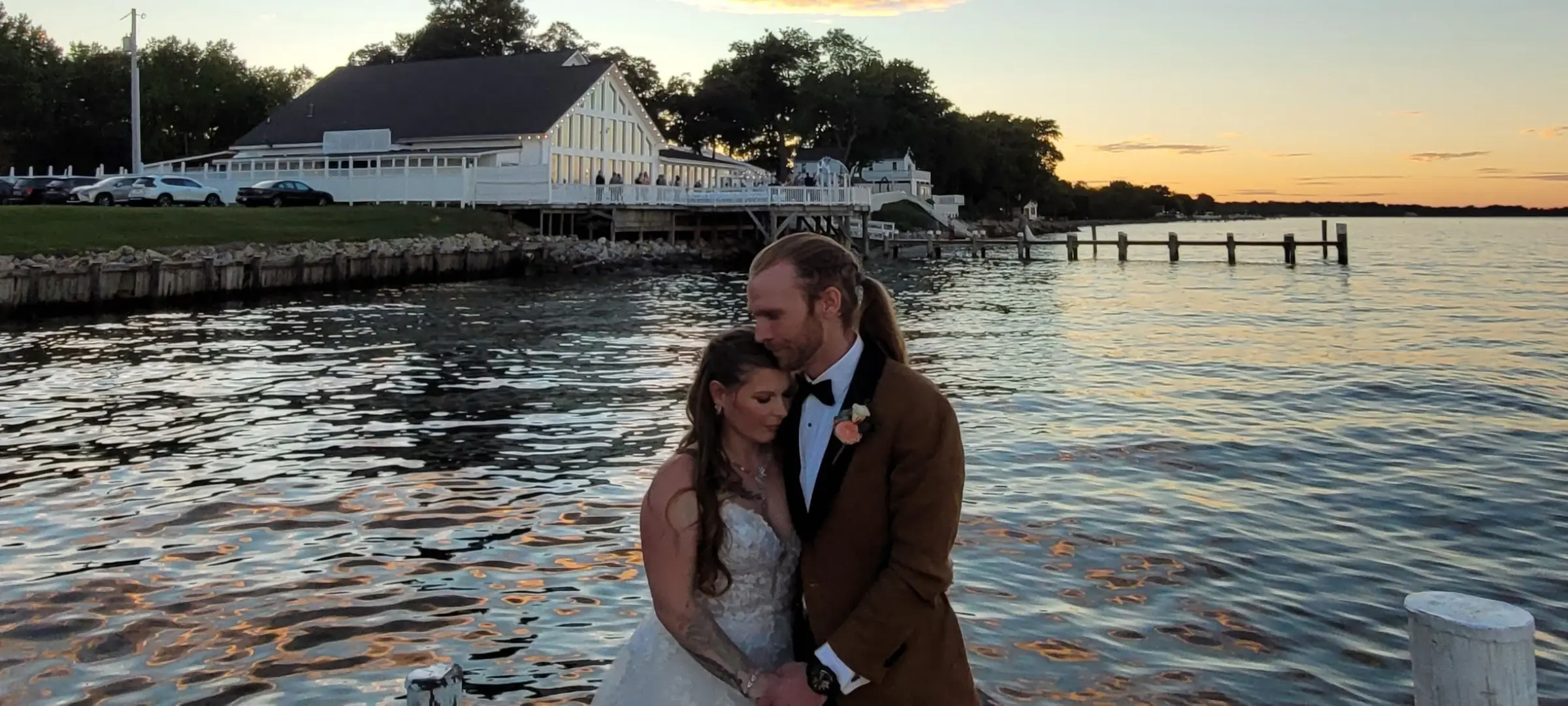 Bride Wearing Princess Wedding Dress With Long Sleeves Called Stevie By Maggie Sottero With Groom On The Dock At Sunset