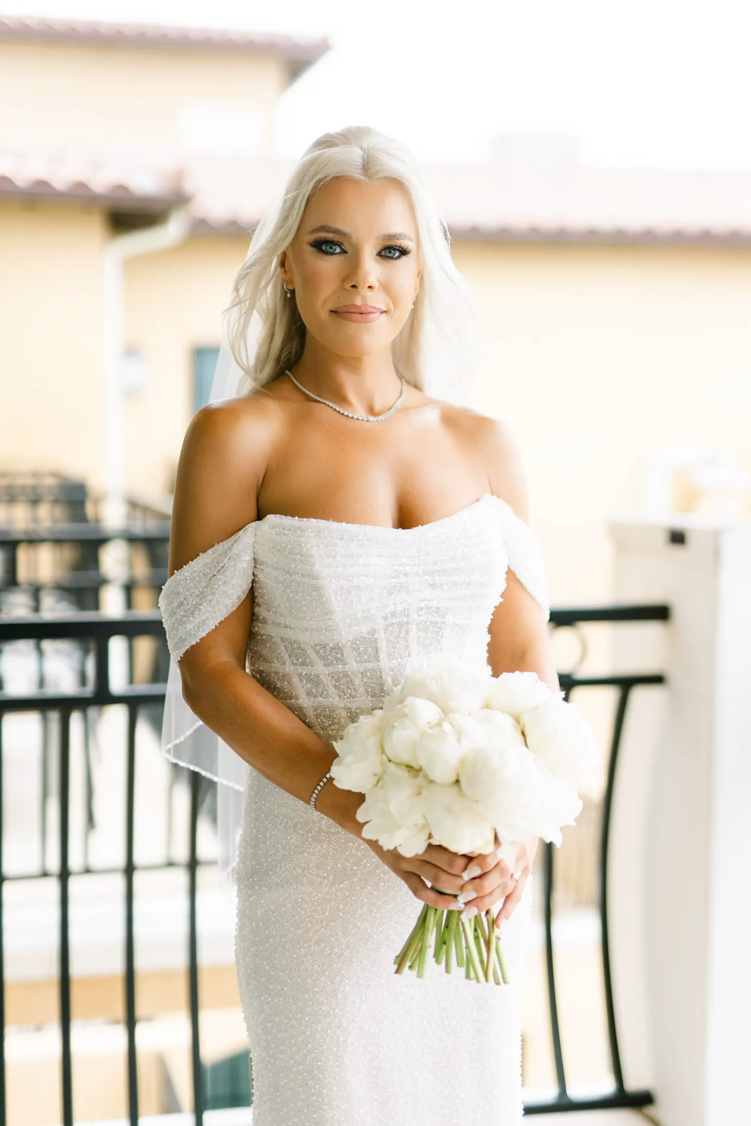 Bride Wearing Pearl Sparkly Bridal Gown Called Drew By Maggie Sottero Holding White Rose Bouquet