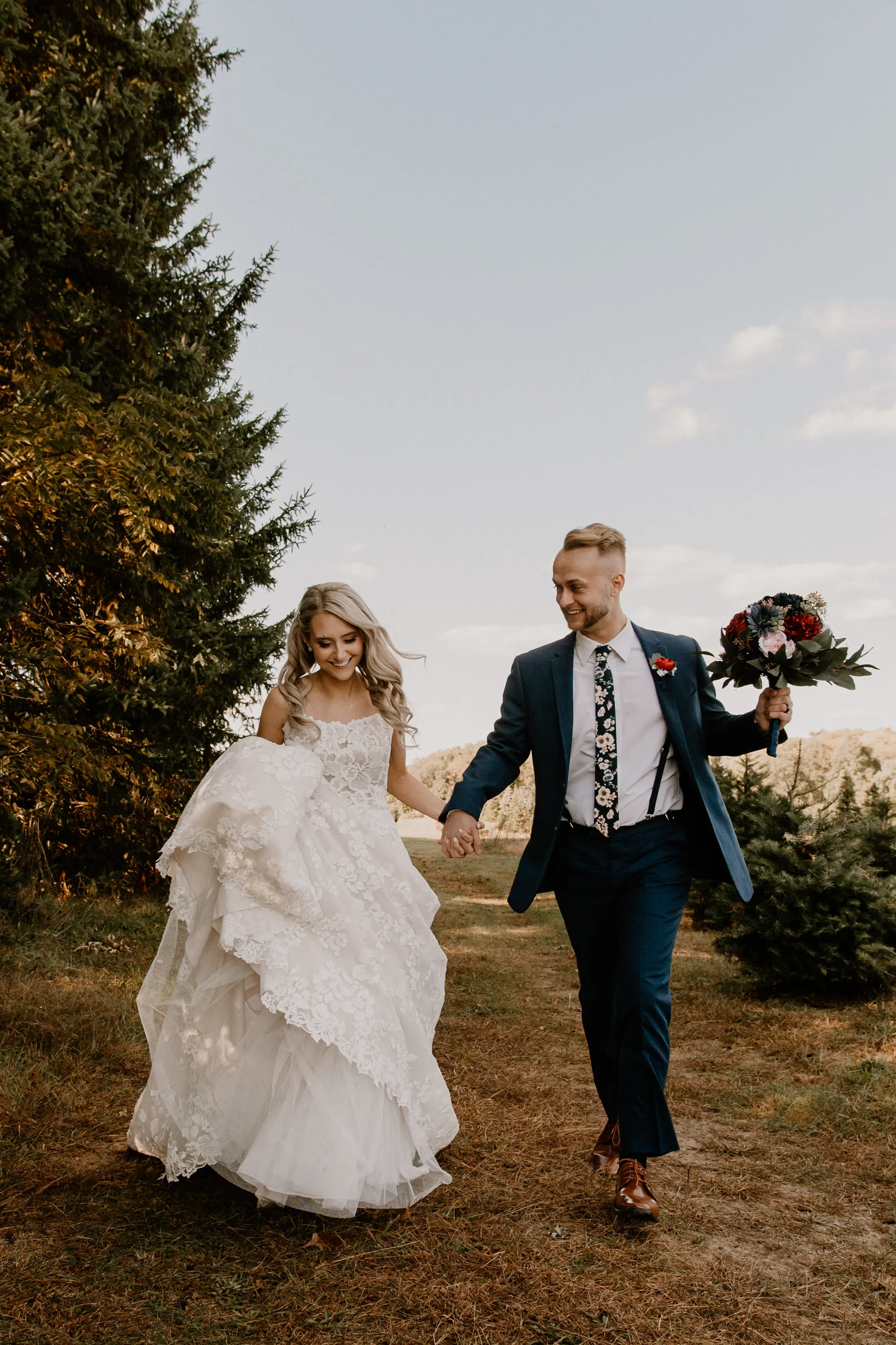 Bride Wearing Square Neck Long Sleeve Floral Wedding Dress Called Sawyer By Sottero And Midgley Walking With Groom Holding Her Bouquet