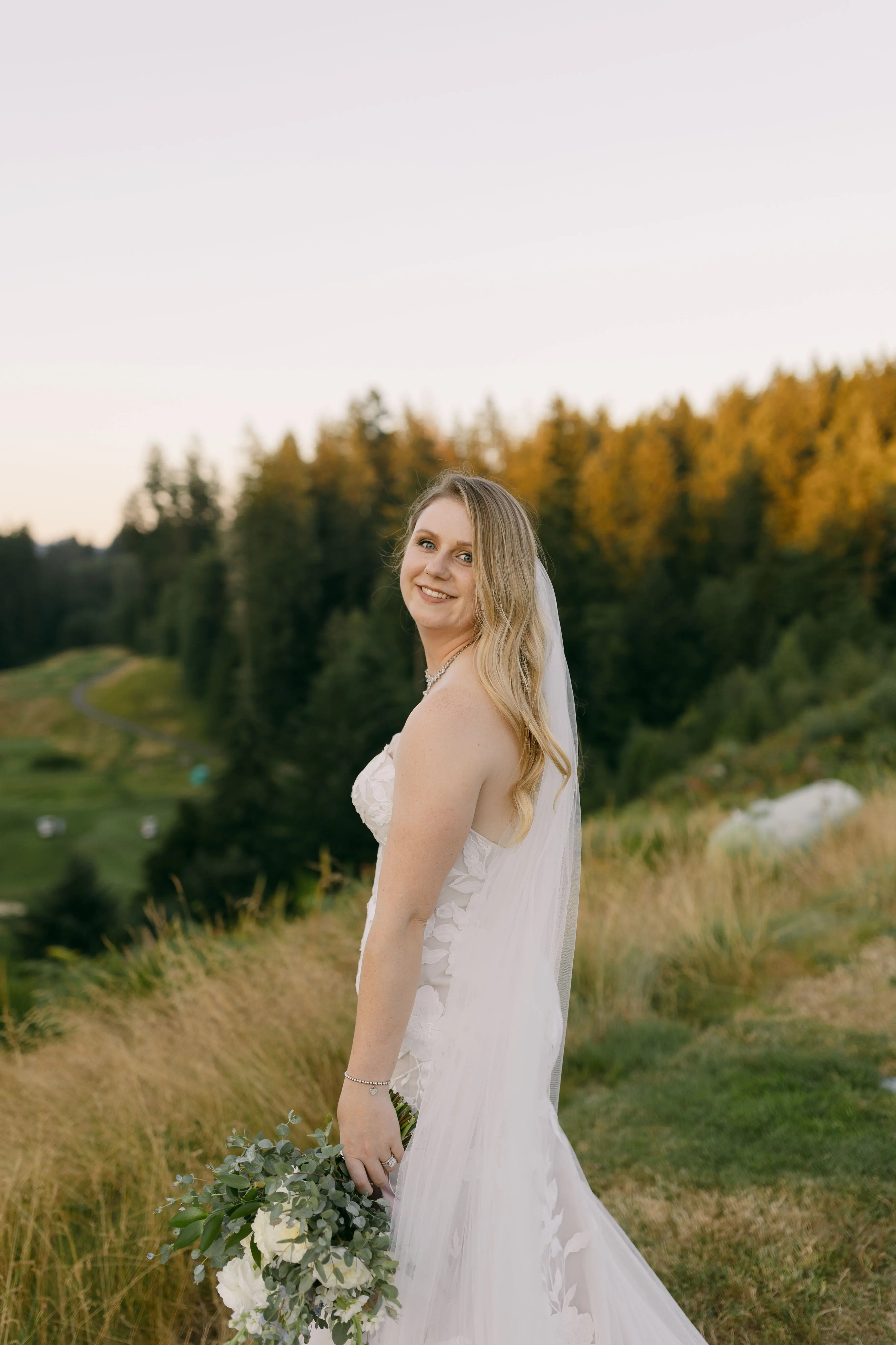 Bride in Strapless Mermaid Wedding Dress Named Hattie By Rebecca Ingram Bride Holding Flowers