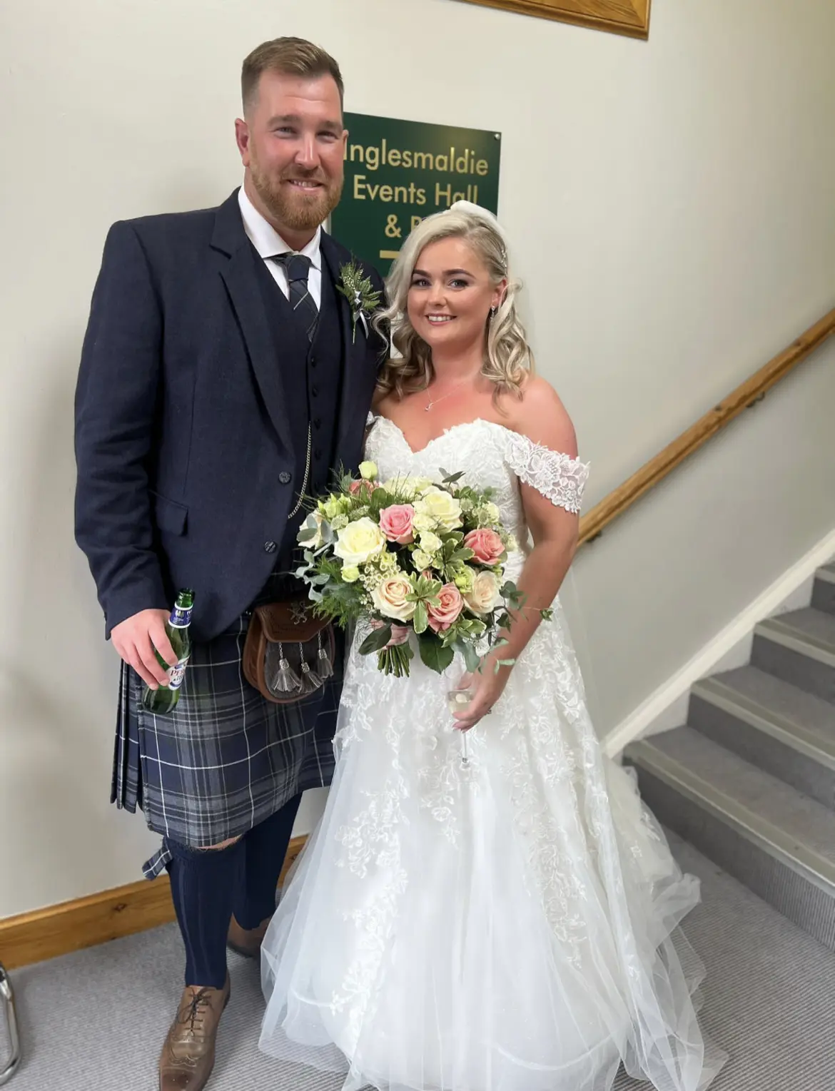 Bride wearing Rousseau wedding dress by Maggie Sottero next to her groom