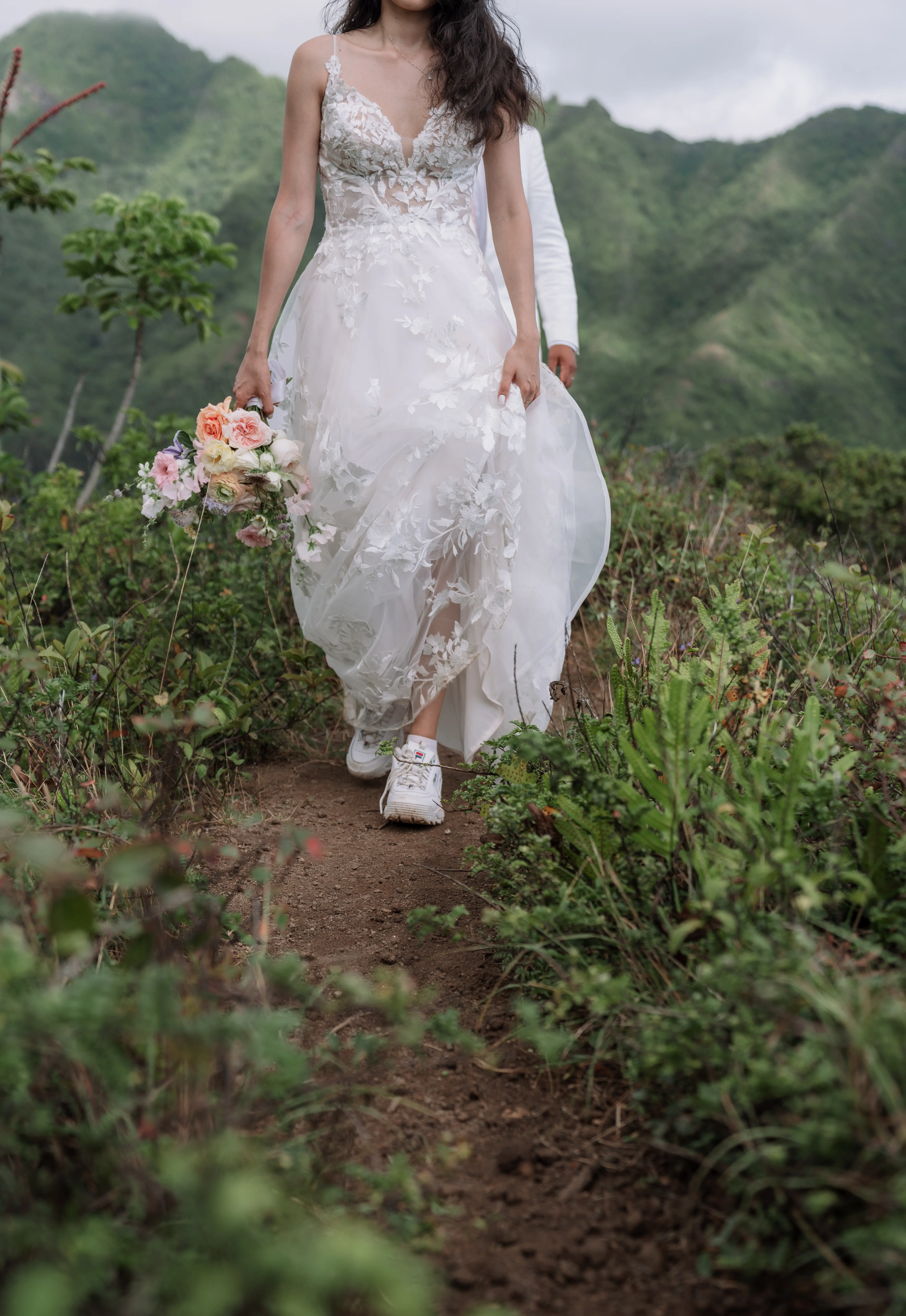 Bride wearing Winter wedding dress by Maggie Sottero hikes in tennis shoes