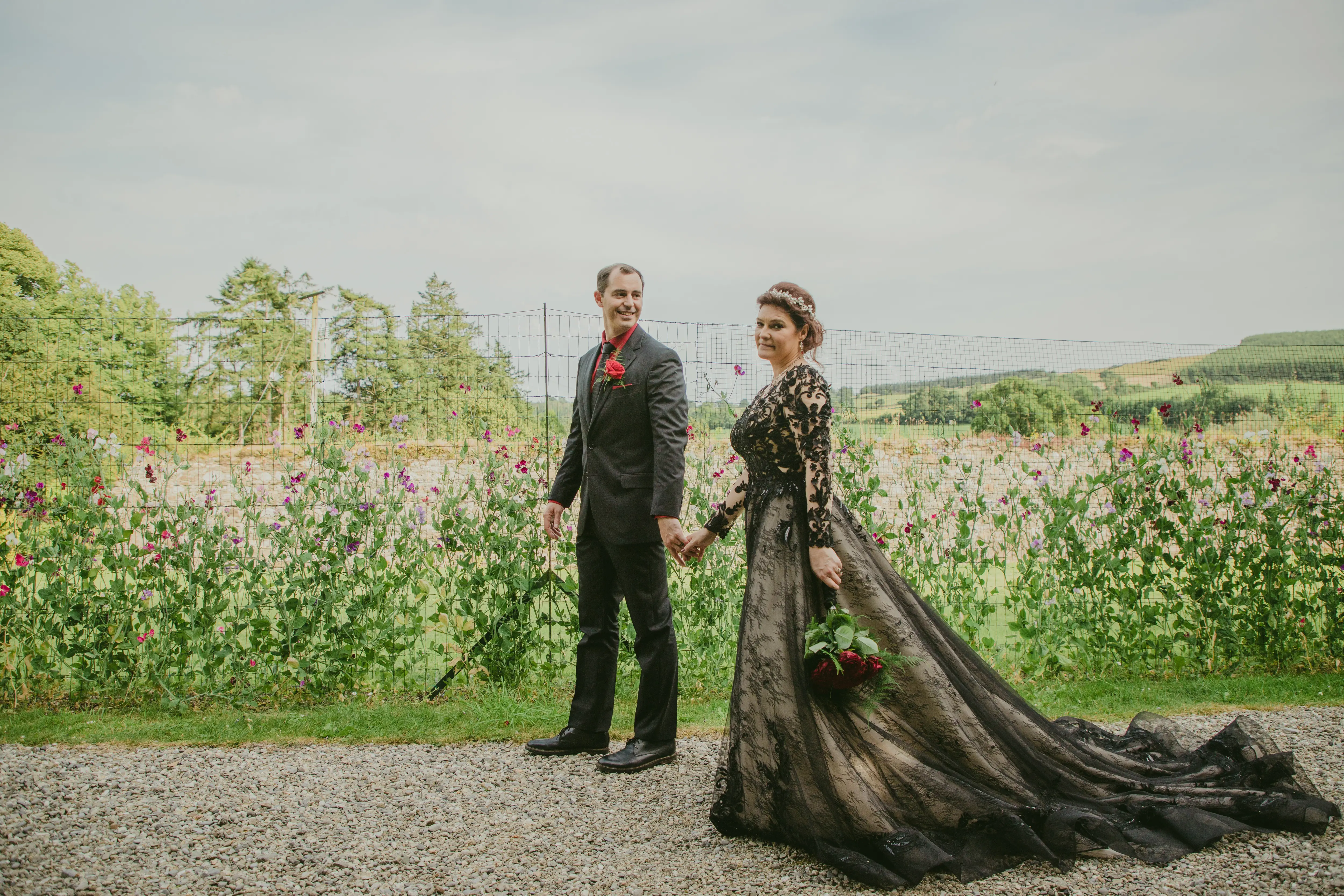 Bride wearing Zander wedding dress by Sottero and Midgley walking with her husband