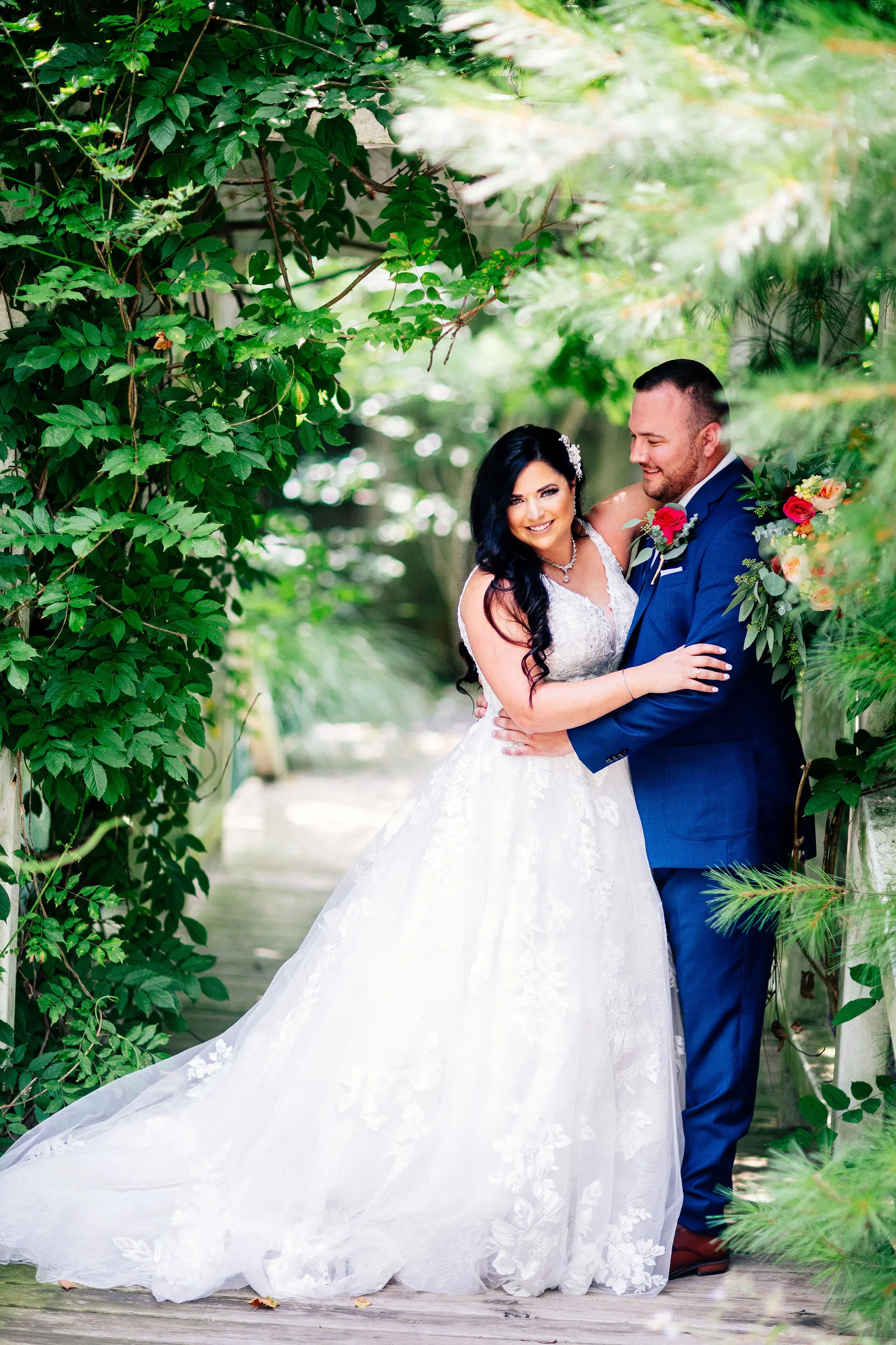 Bride hugging her groom in the bushes.
