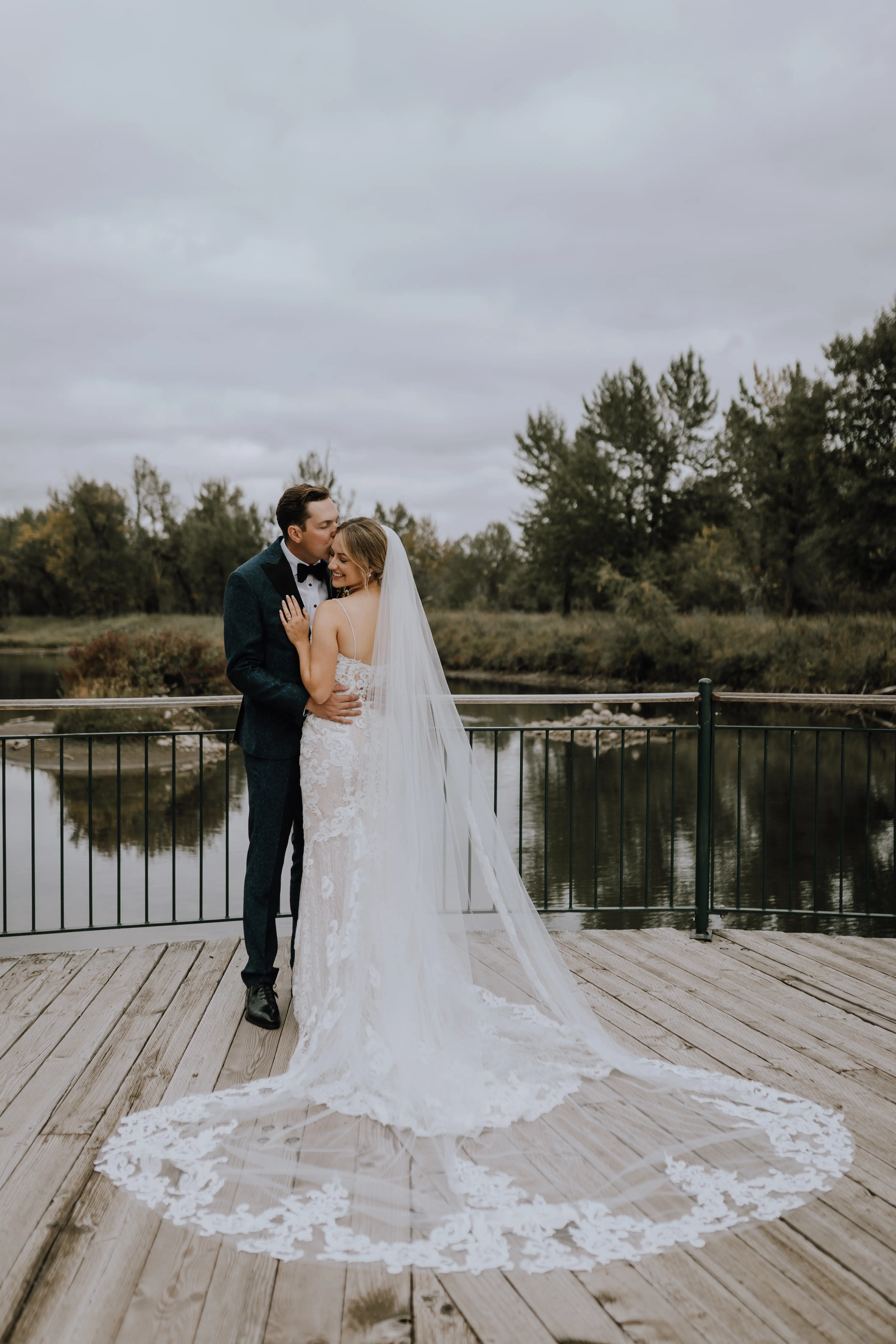 Bride with groom wearing a romantic lace sheath wedding dress.