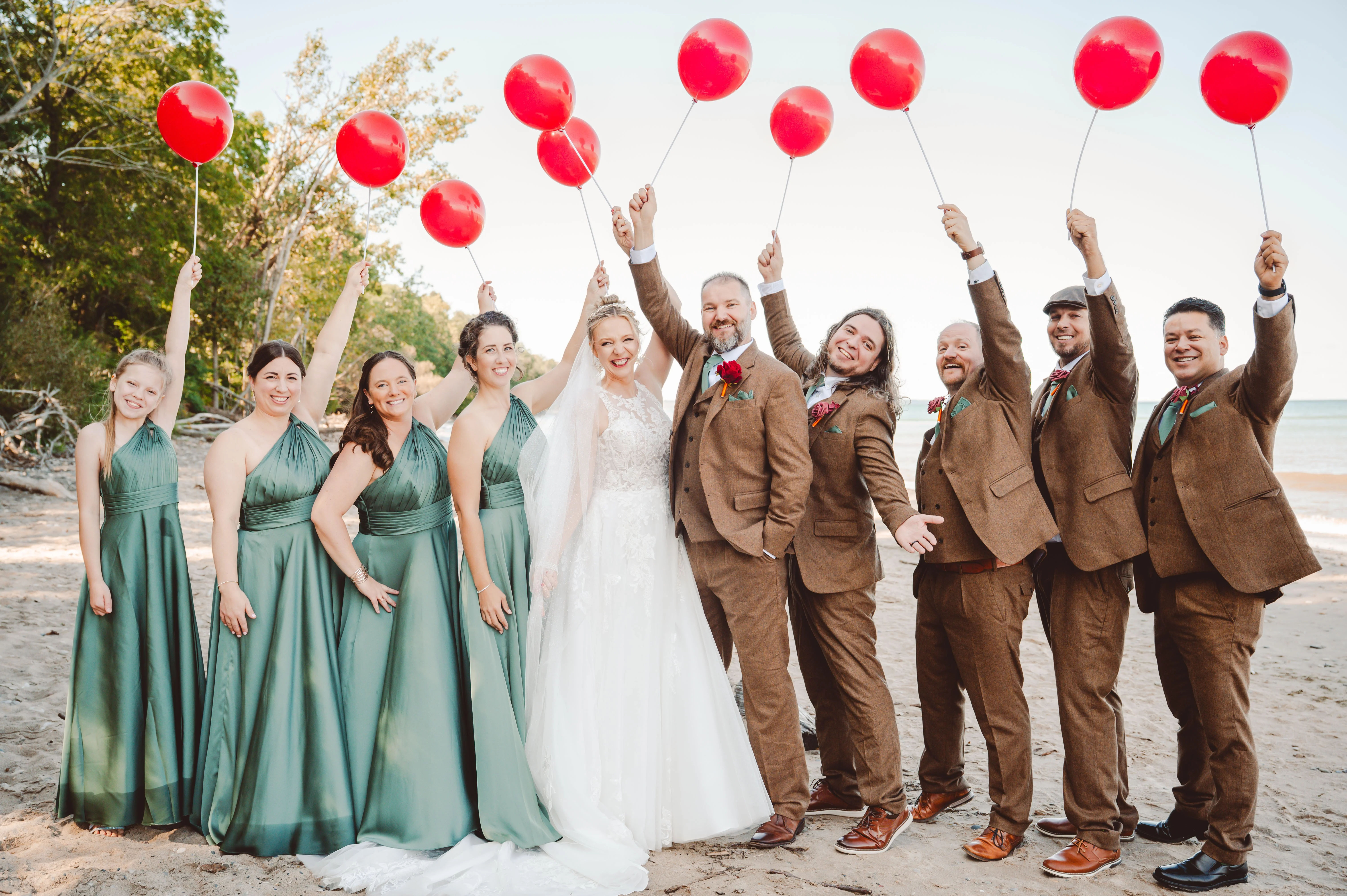 Bride wearing Lace Aline Wedding Dress Called Rickie By Rebecca Ingram With Bridal Party Holding Red Balloons