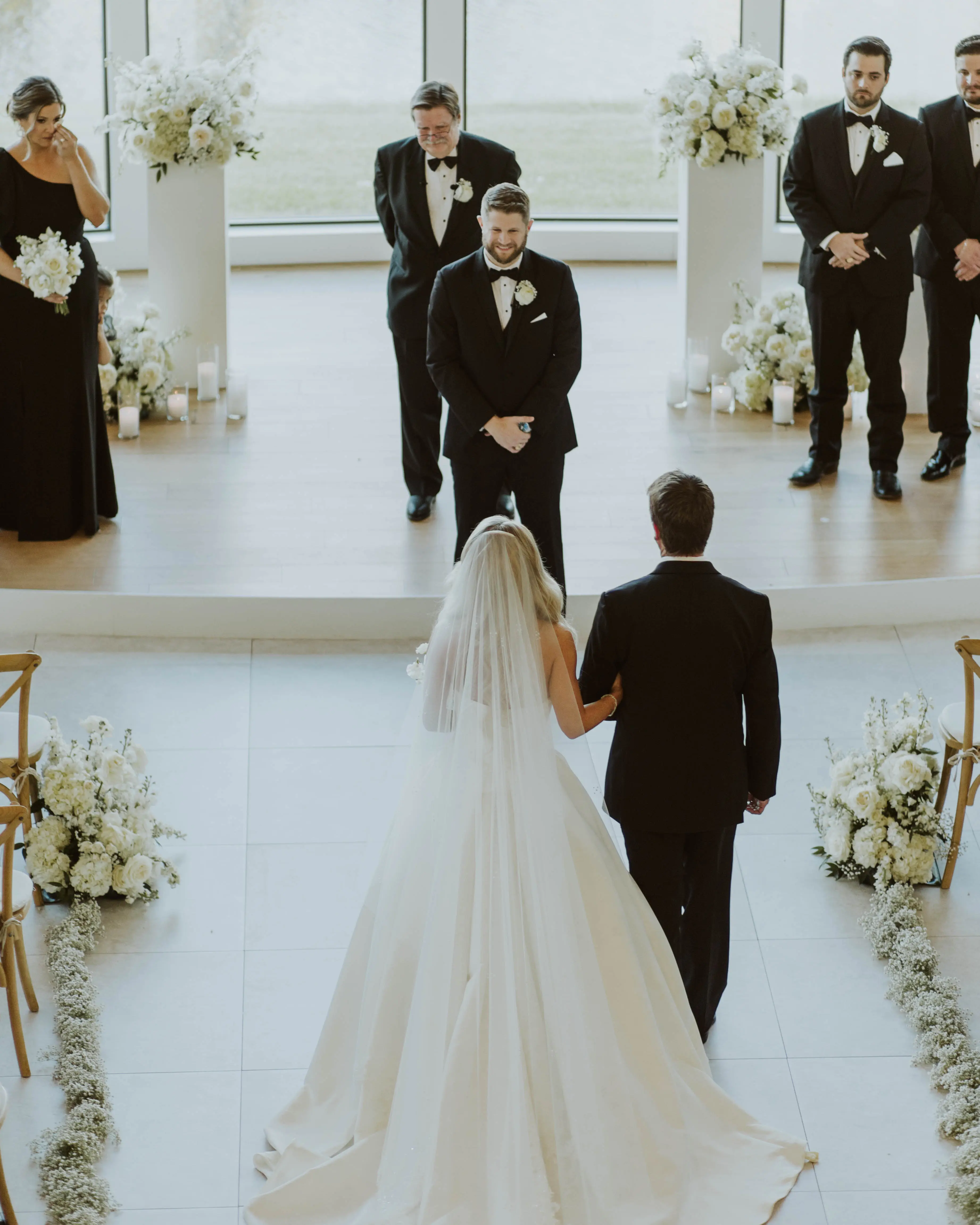 Bride wearing Derrick by Maggie Sottero walking down the aisle with her dad