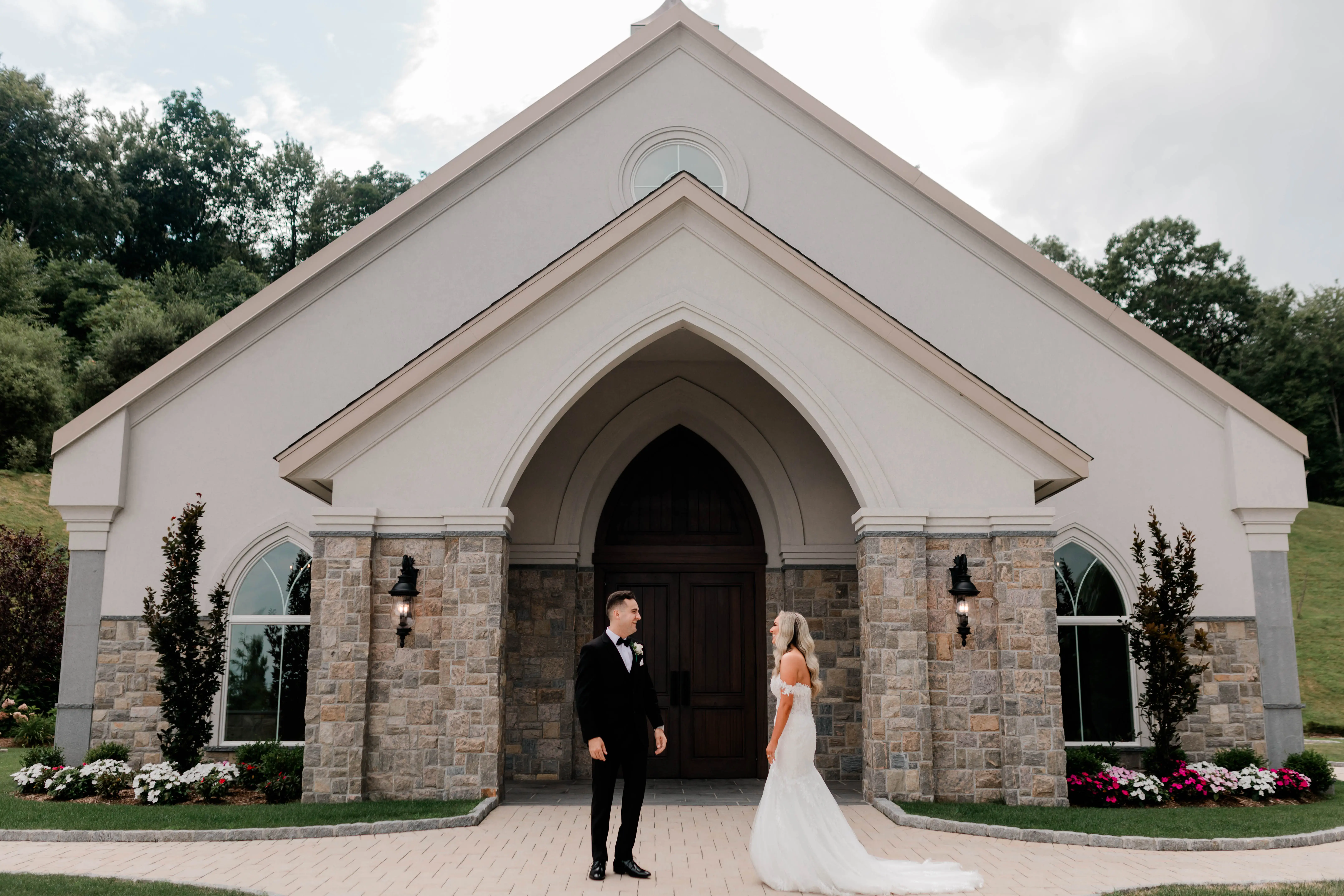 Bride wearing Lennon by Maggie Sottero outside of a church with her husband