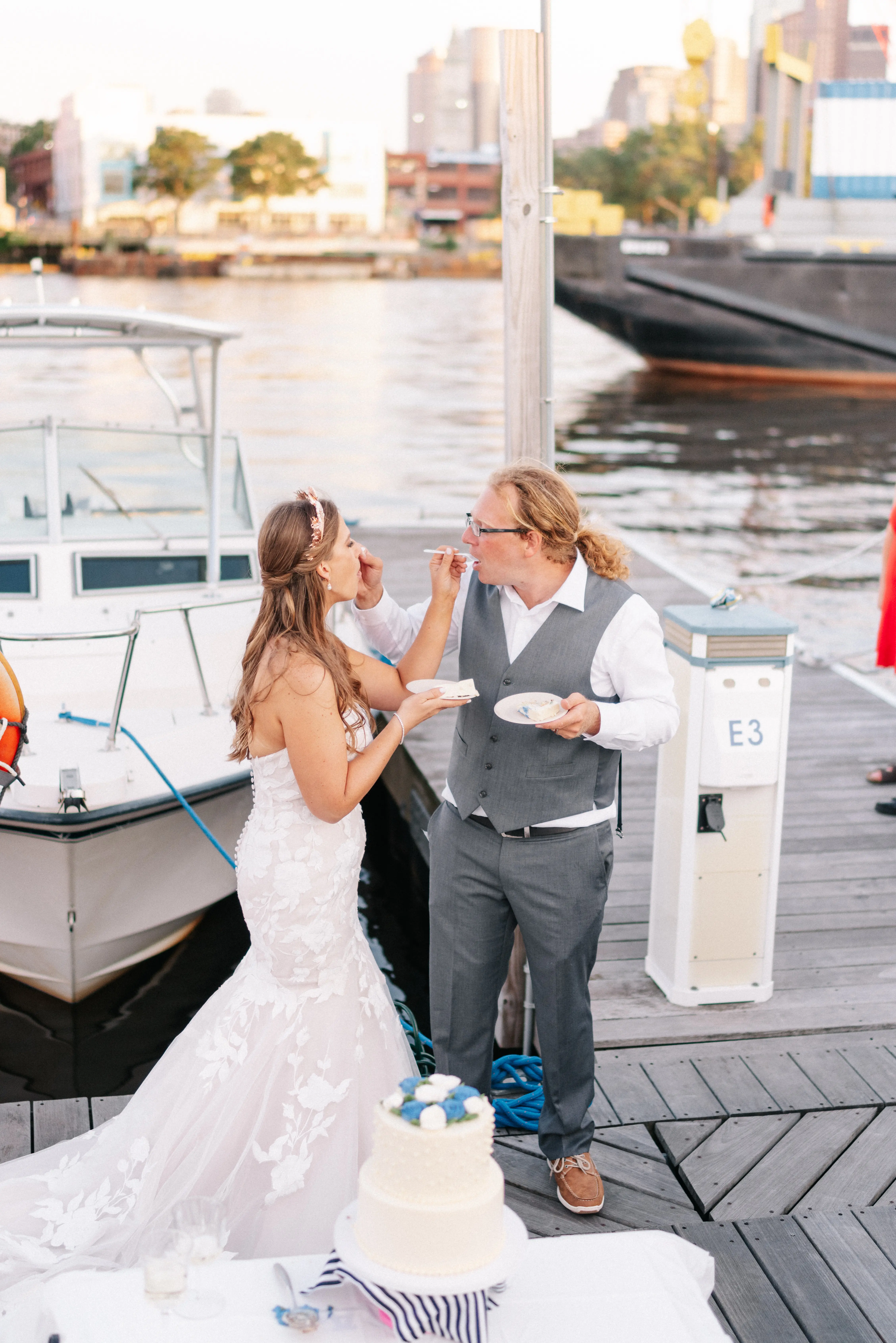 Bride with groom wearing strapless mermaid wedding dress with plunging V-neck.