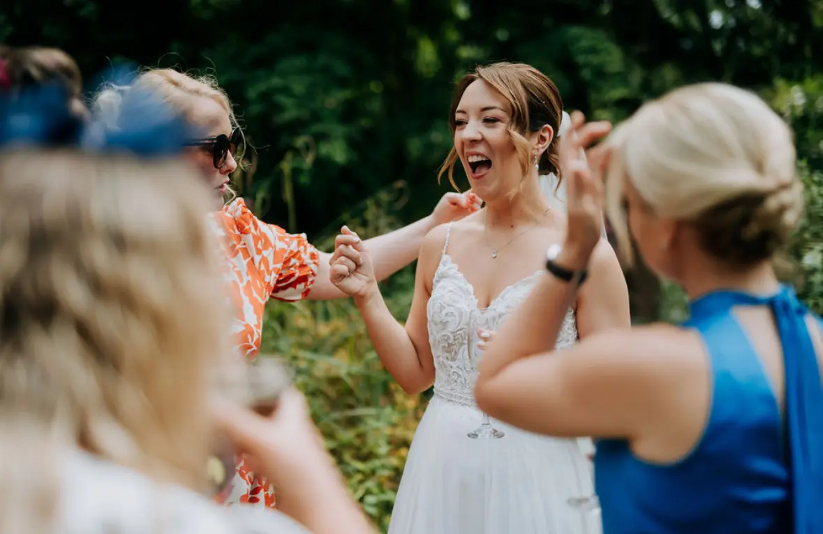 Bride wearing Lorraine by Rebecca Ingram talking to loved ones