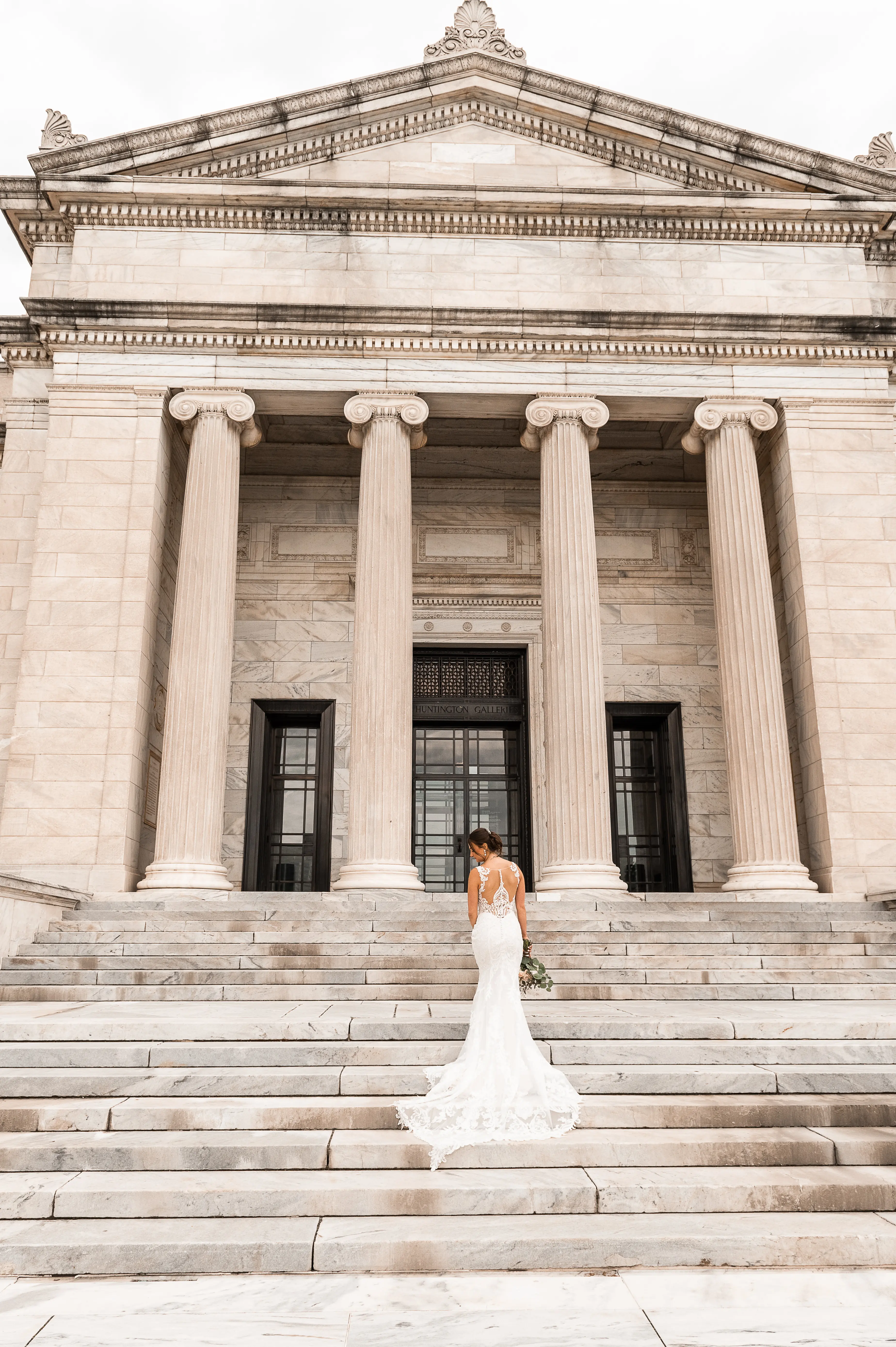 Bride Wearing Sheath Lace Wedding Dress Called Hamilton Lynette By Sottero And Midgley On The Steps Of An Art Gallery
