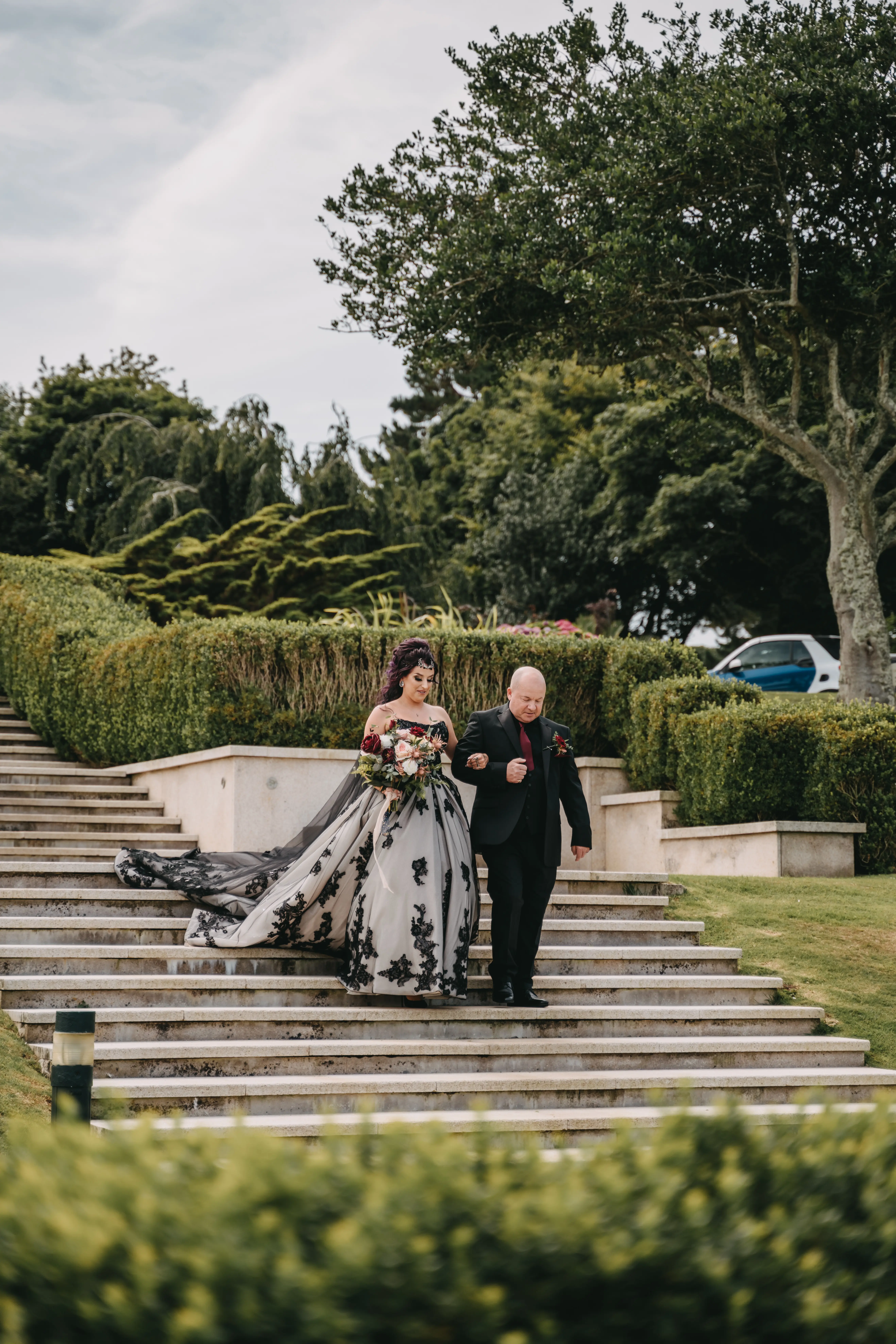 Bride wearing Norvinia by Sottero and Midgley walking down the stairs with a loved one