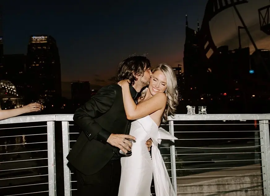 Groom With Bride Wearing Unique Strapless Wedding Dress With Beautiful Back Bow Mitchell By Maggie Sottero
