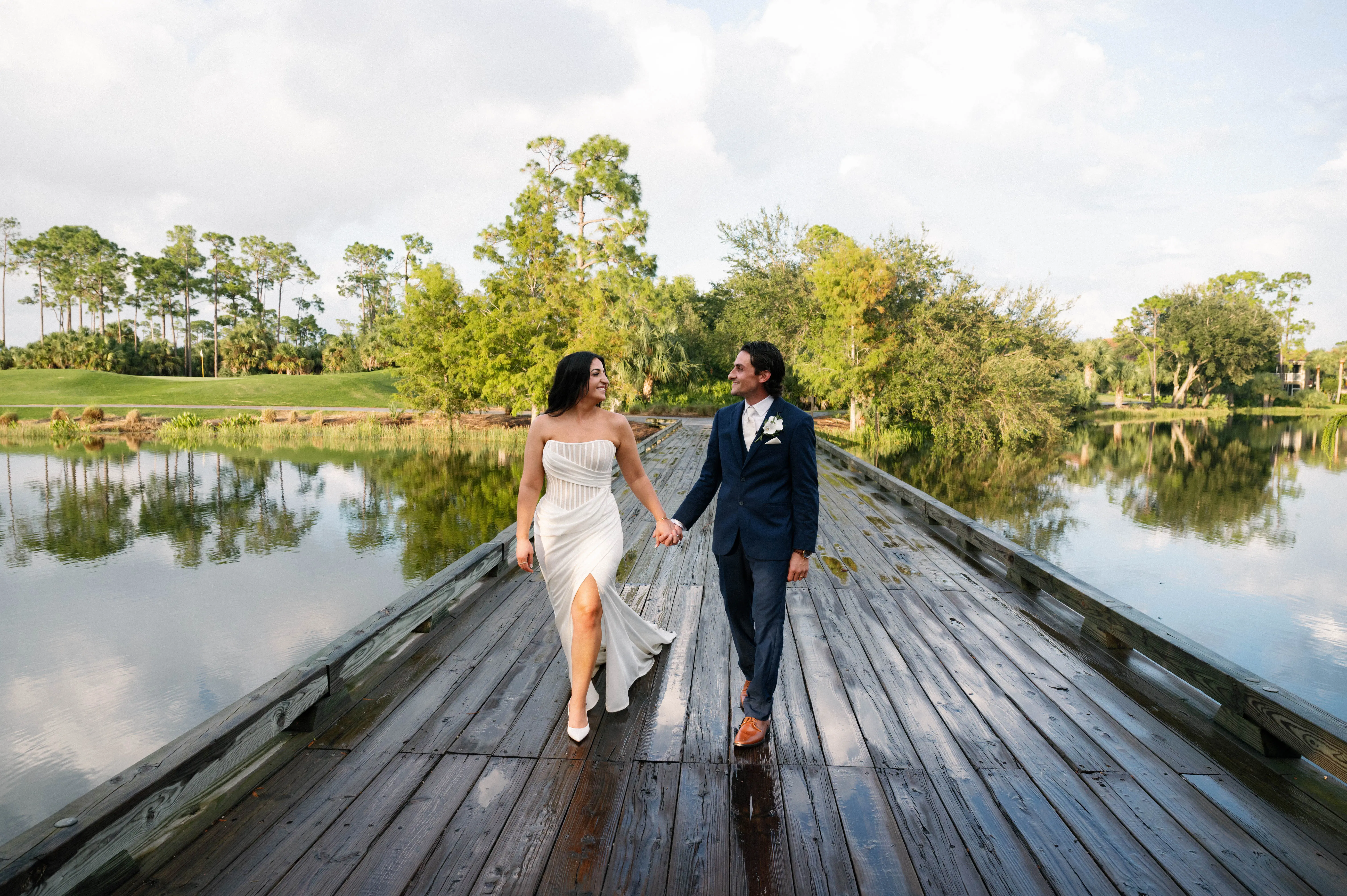 Bride Wearing Grecian Inspired Wedding Dress Called Gabrielle By Maggie Sottero On A Boardwalk With Groom