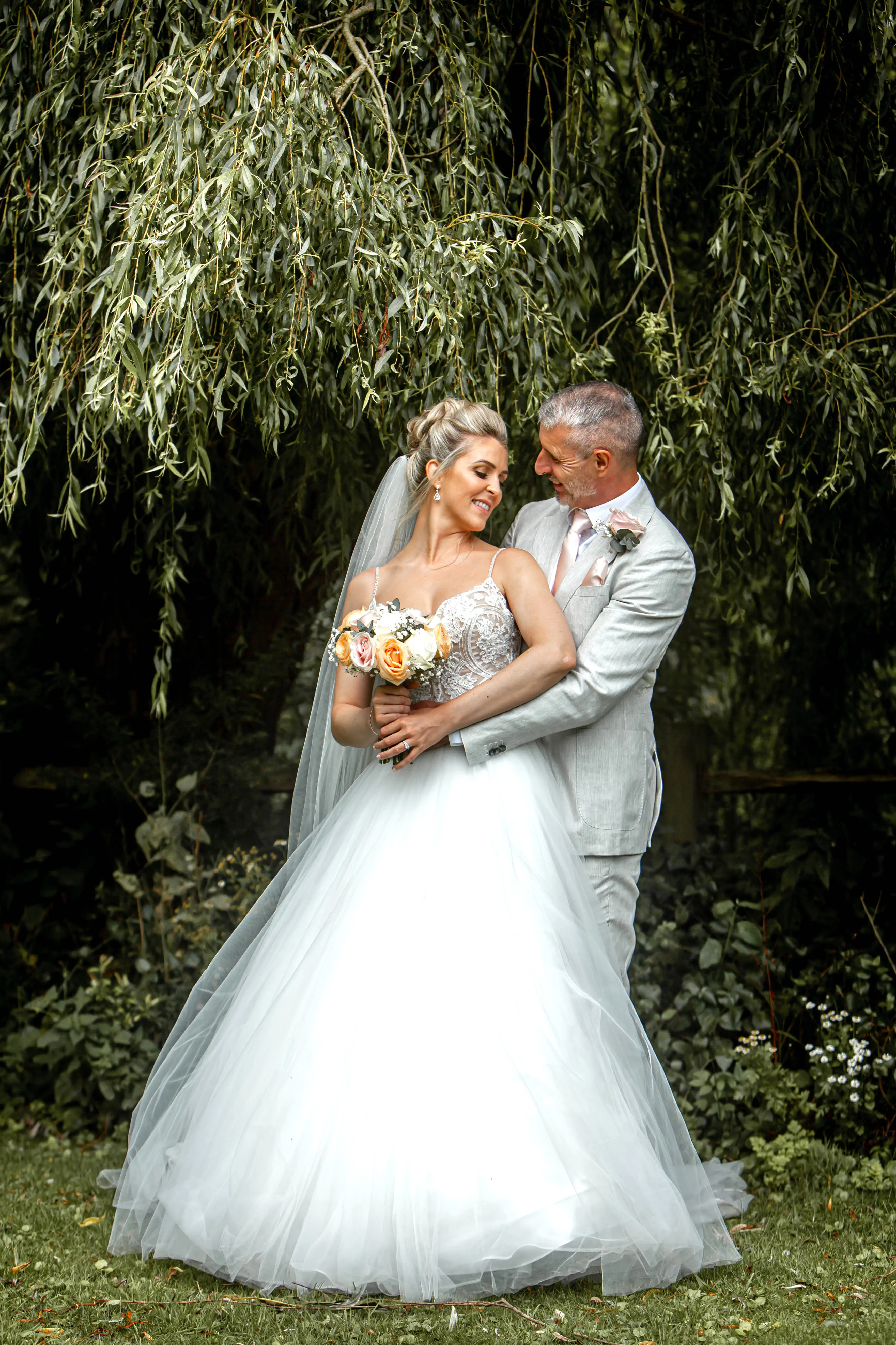 Groom holding his bride wearing wedding dress called Mallory.