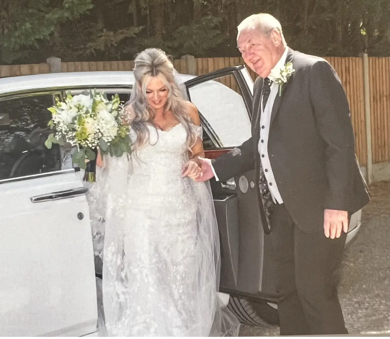 Bride Stepping Out Of Car With Father Of The Bride. Bride Wearing 3D Lace Wedding Dress With 3D Floral Details Called Ryker By Sottero And Midgley