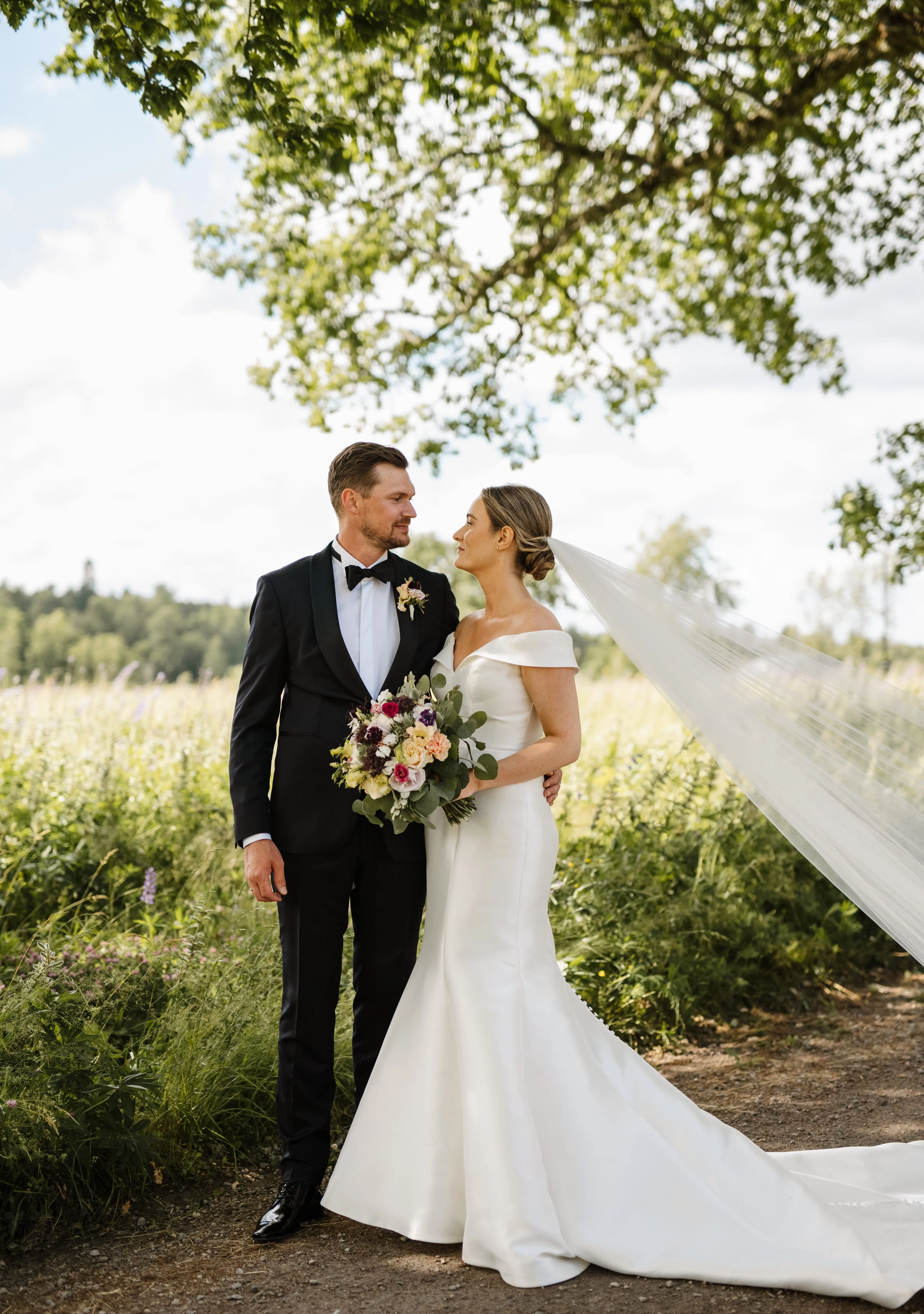 Groom With Bride Wearing Off The Shoulder Fit And Flare Josie By Rebecca Ingram