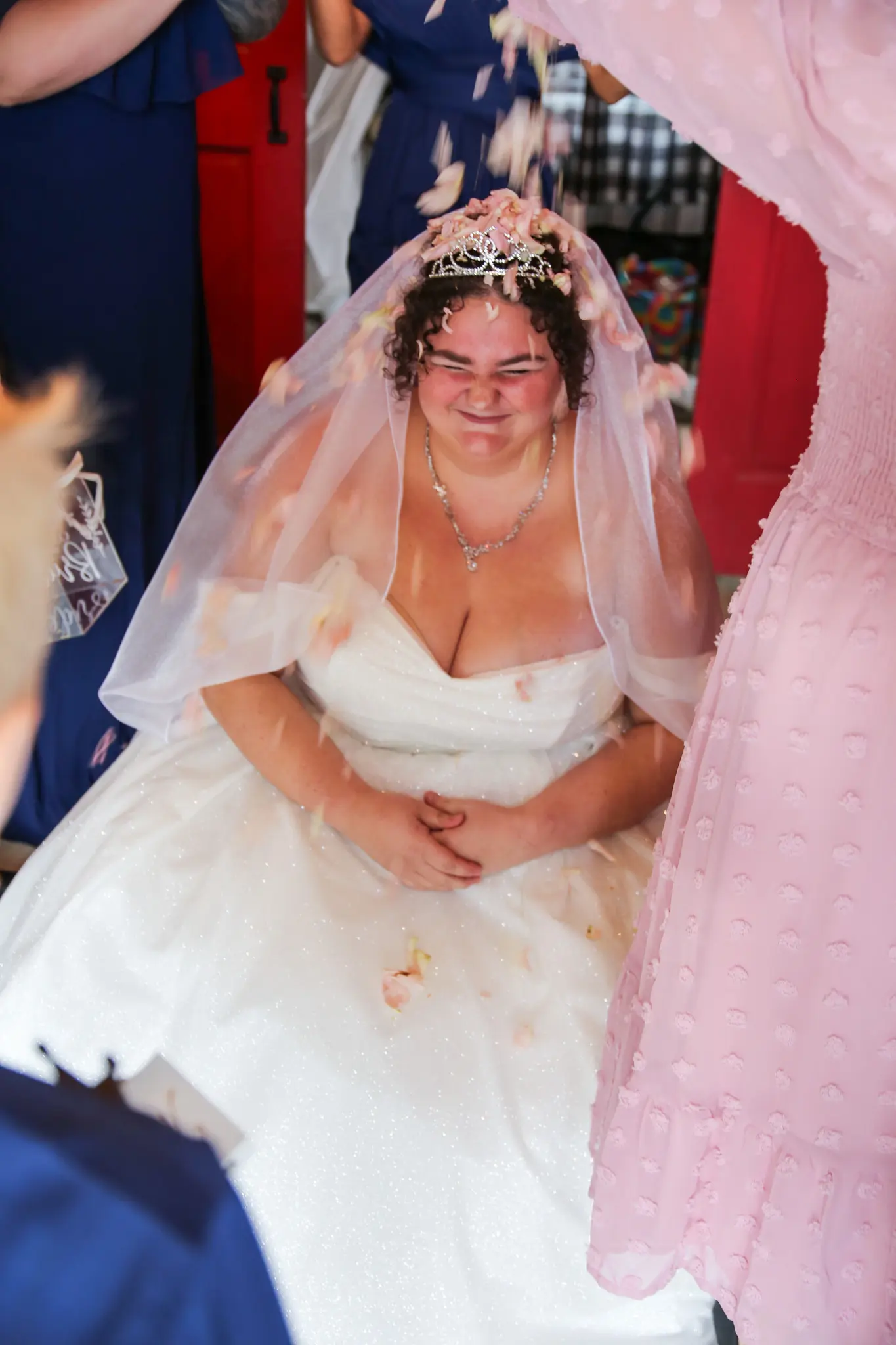 Bride wearing Anniston by Maggie Sottero having flower petals put on her