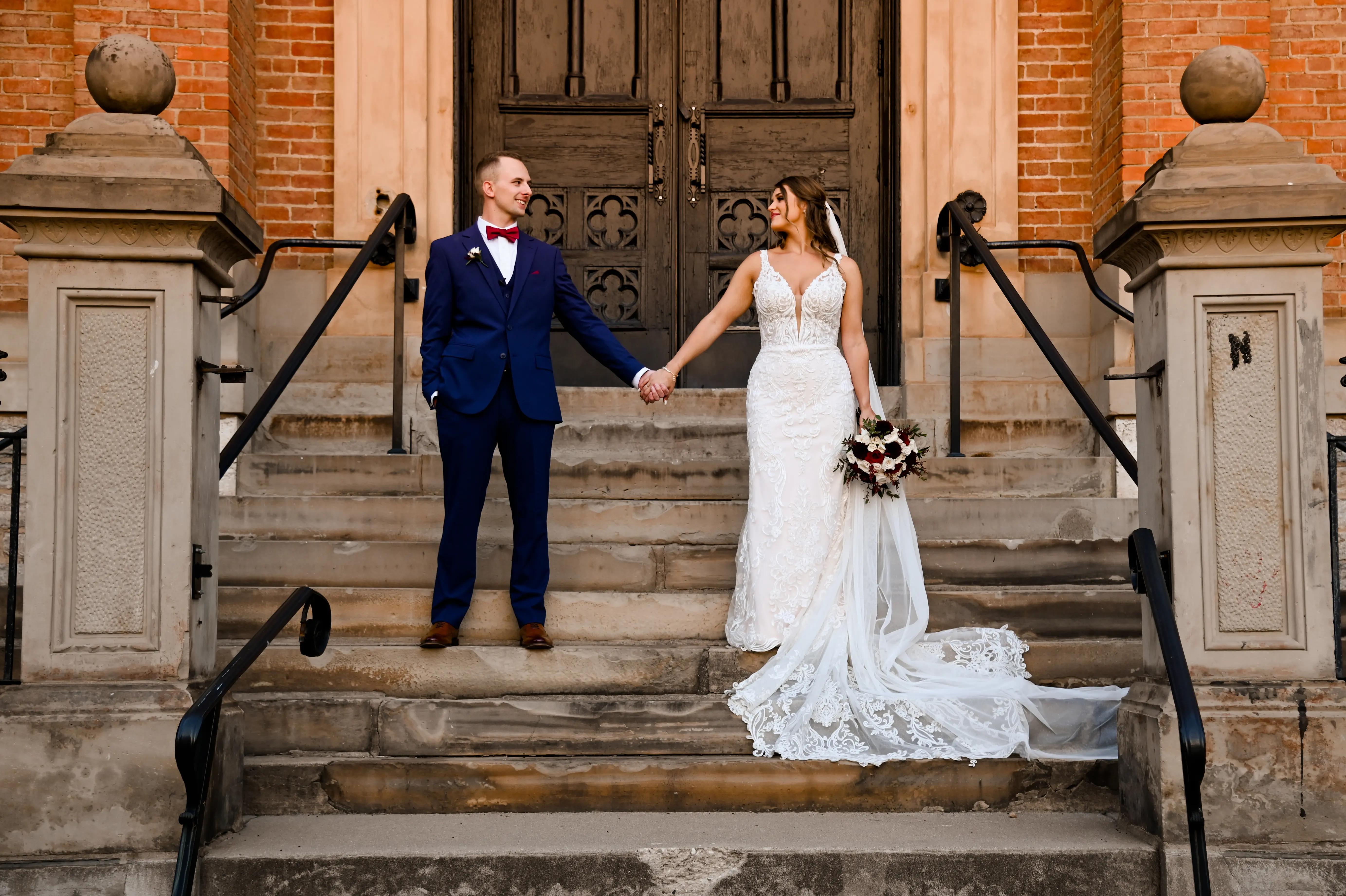 Bride wearing Hamilton wedding dress by Sottero and Midgley holding hands with her husband