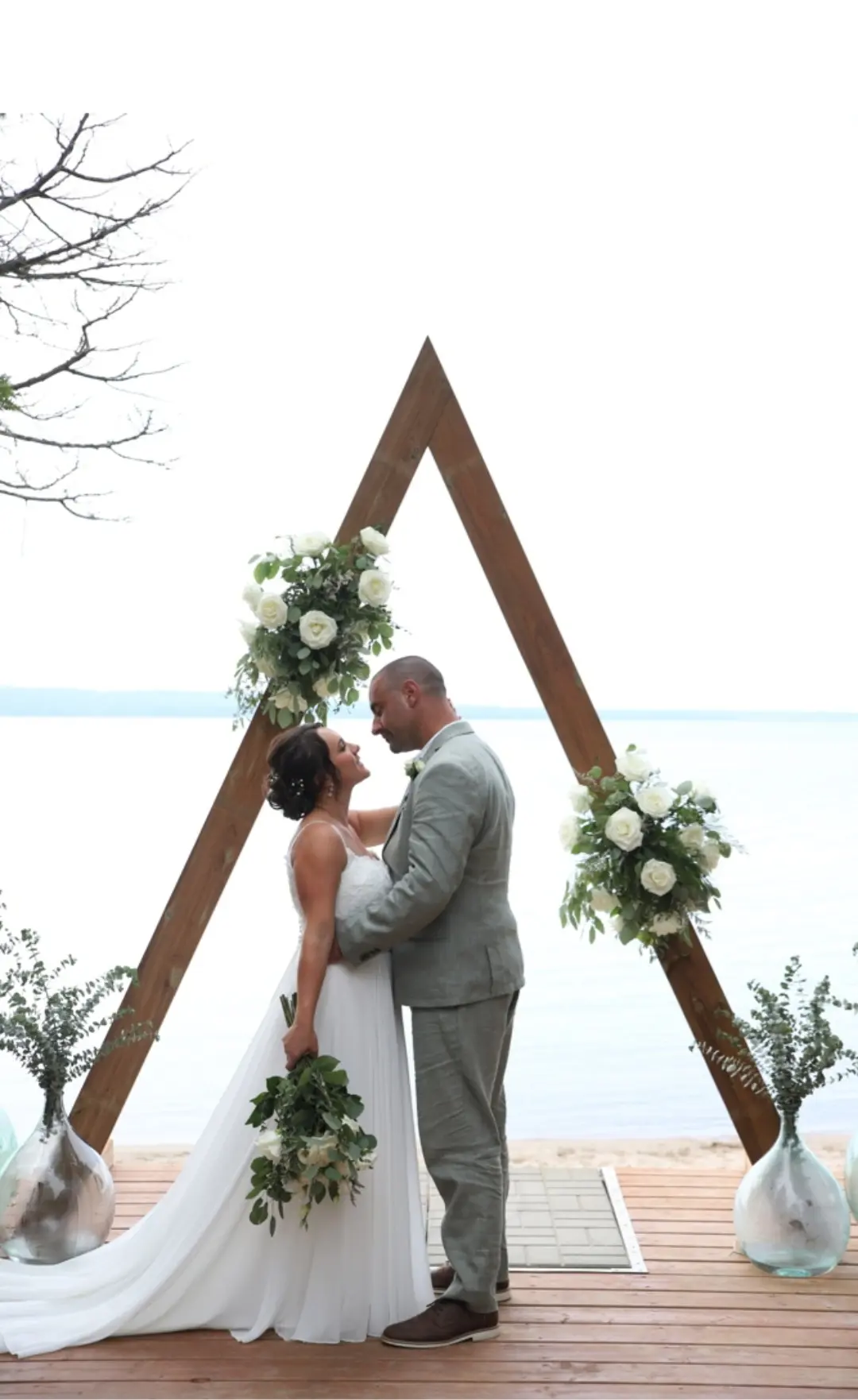 Bride Wearing Simple Chiffon Wedding Dress Called Marta Lynette By Rebecca Ingram Together With Groom Under Triangle Arch