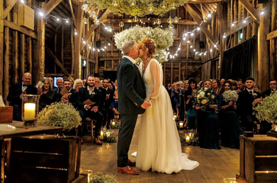 Groom with Bride in Bishop Sleeve A-Line Wedding Gown Called Joanne by Rebecca Ingram