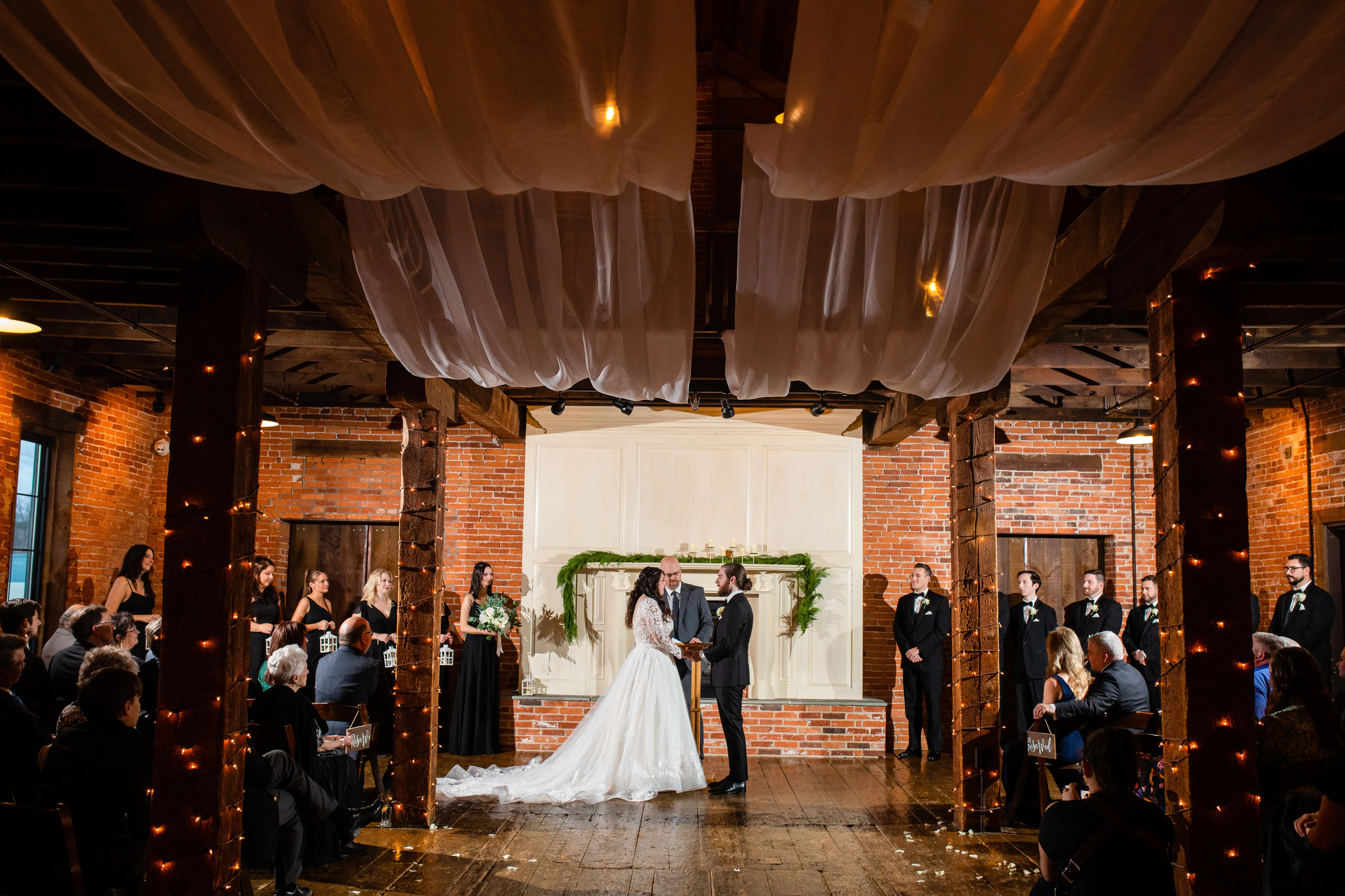 Bride And Groom Standing Together. Bride Wearing Lace Long Sleeve Wedding Dress Called Zander By Sottero And Midgley