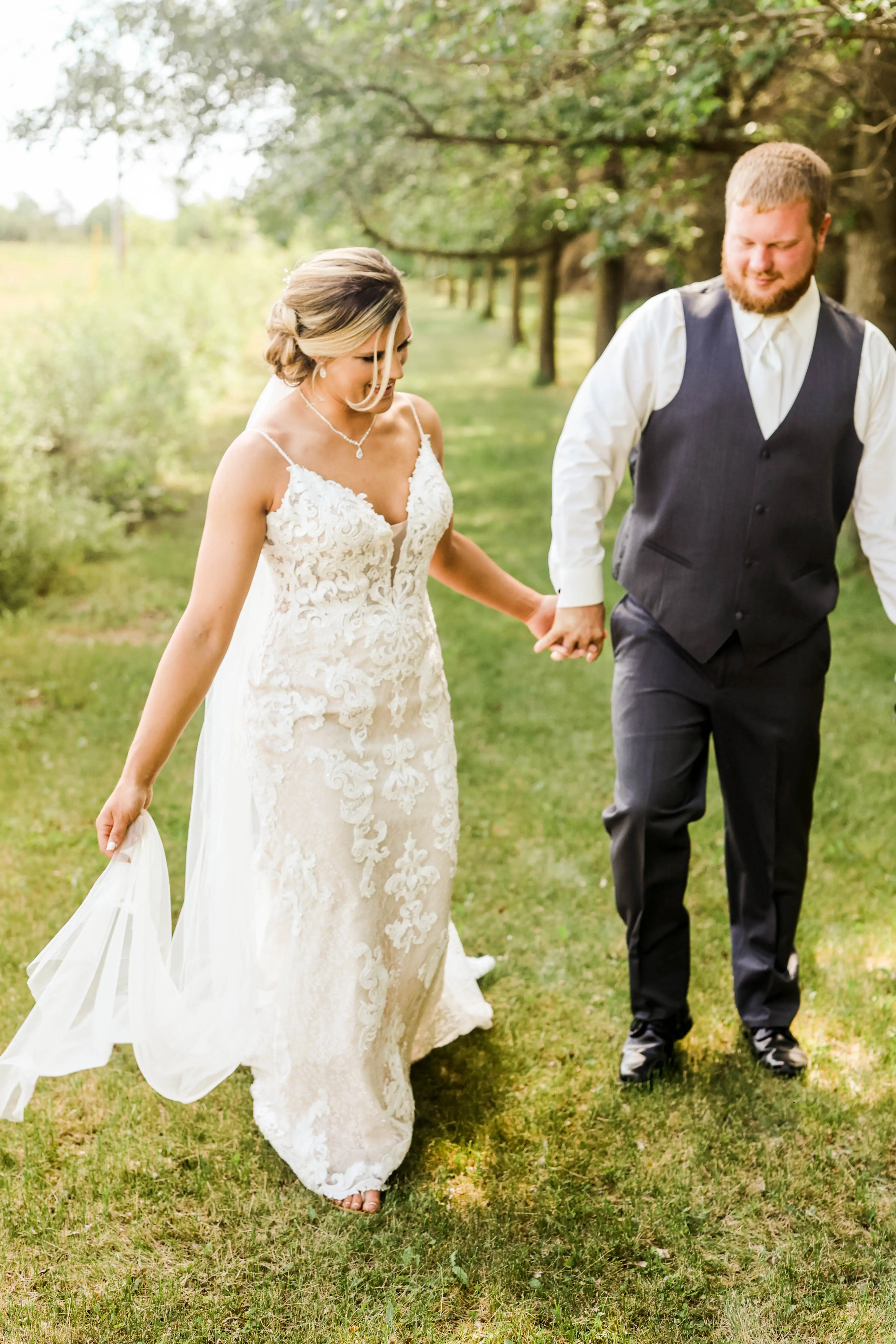 Bride with groom wearing romantic lace sheath wedding dress