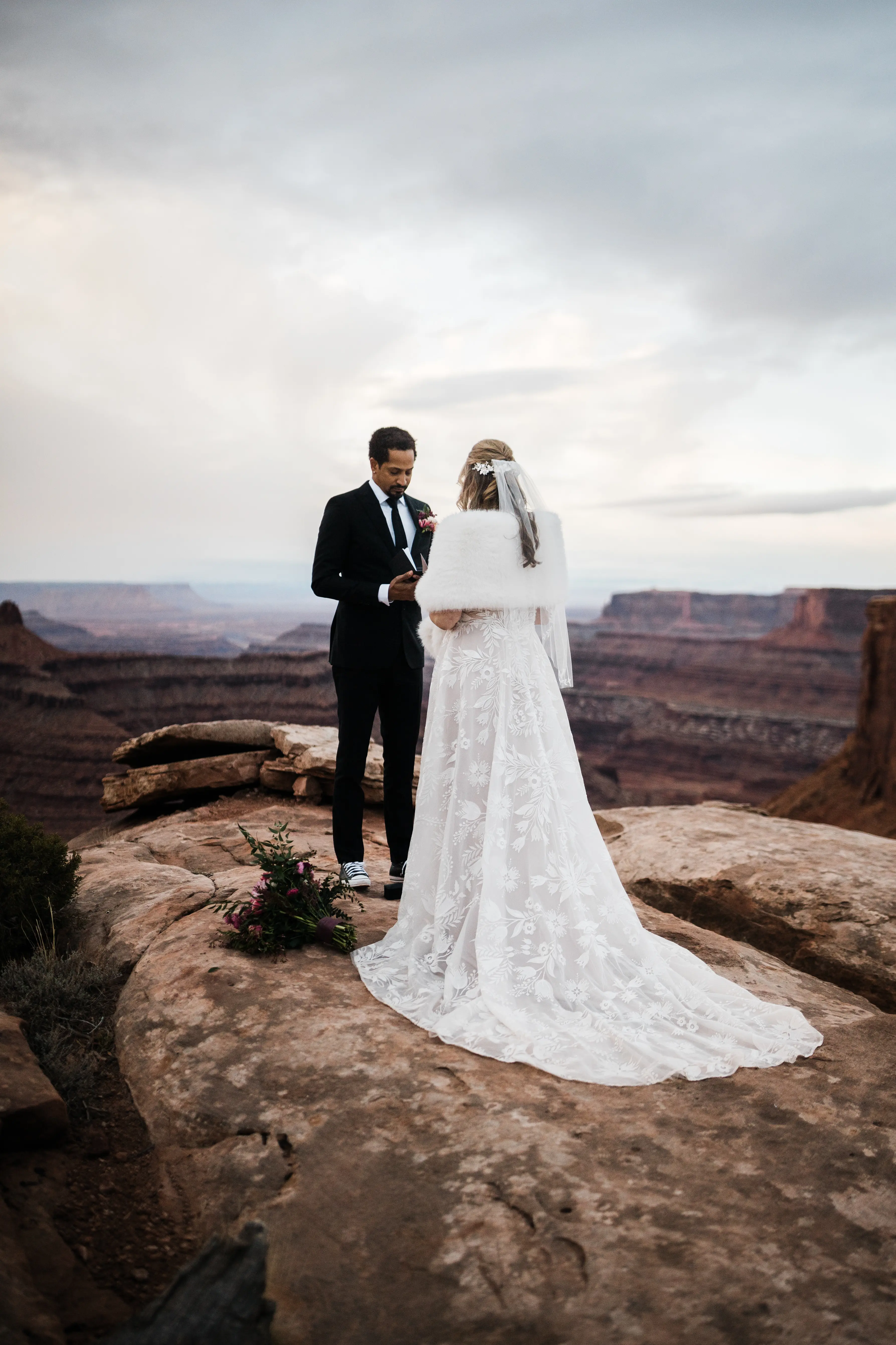 Groom Reading Vows To Bride Wearing A White A Line Wedding Dress Named Keisha By Maggie Sottero Outside On Red Rocks