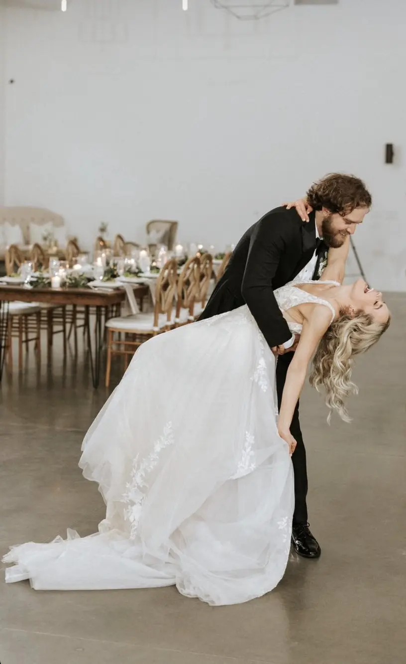 Groom Dancing With Bride Wearing Plunging Lace Illusion Wedding Dress Called Raelynn By Rebecca Ingram