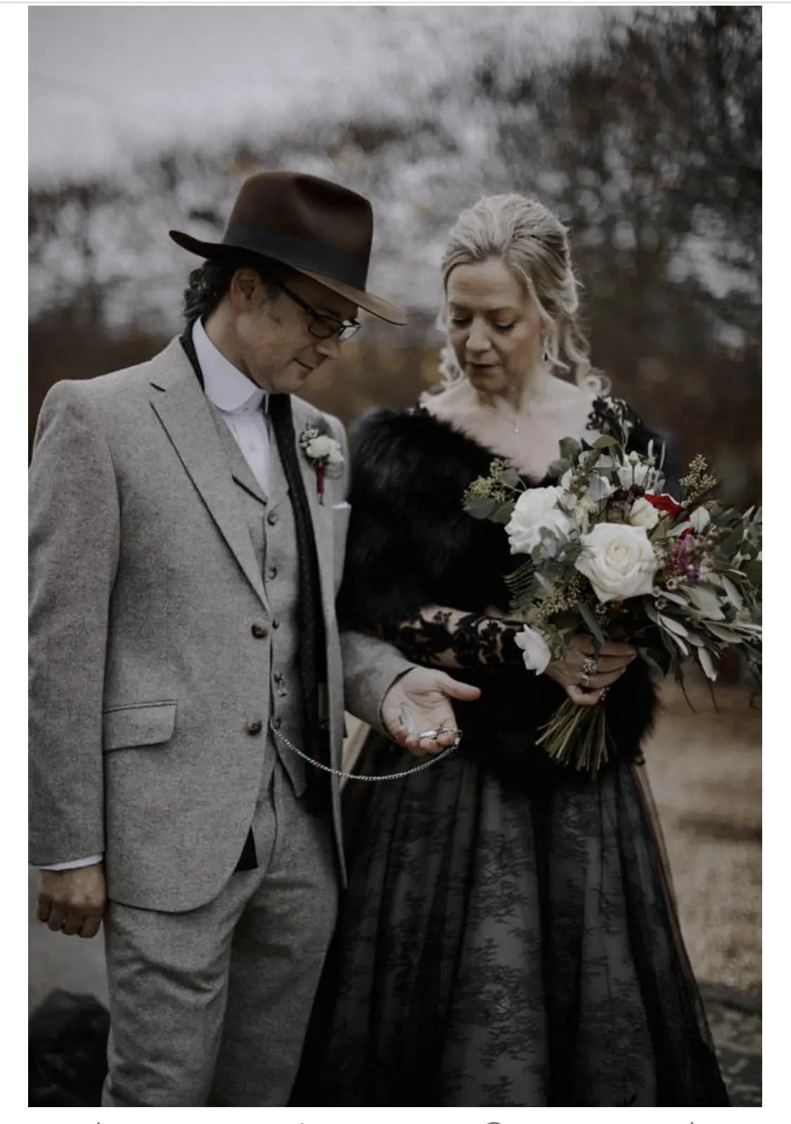 Bride Wearing Black Lace Wedding Gown Called Zander By Sottero and Midgley And Groom Looking At A Pocket Watch