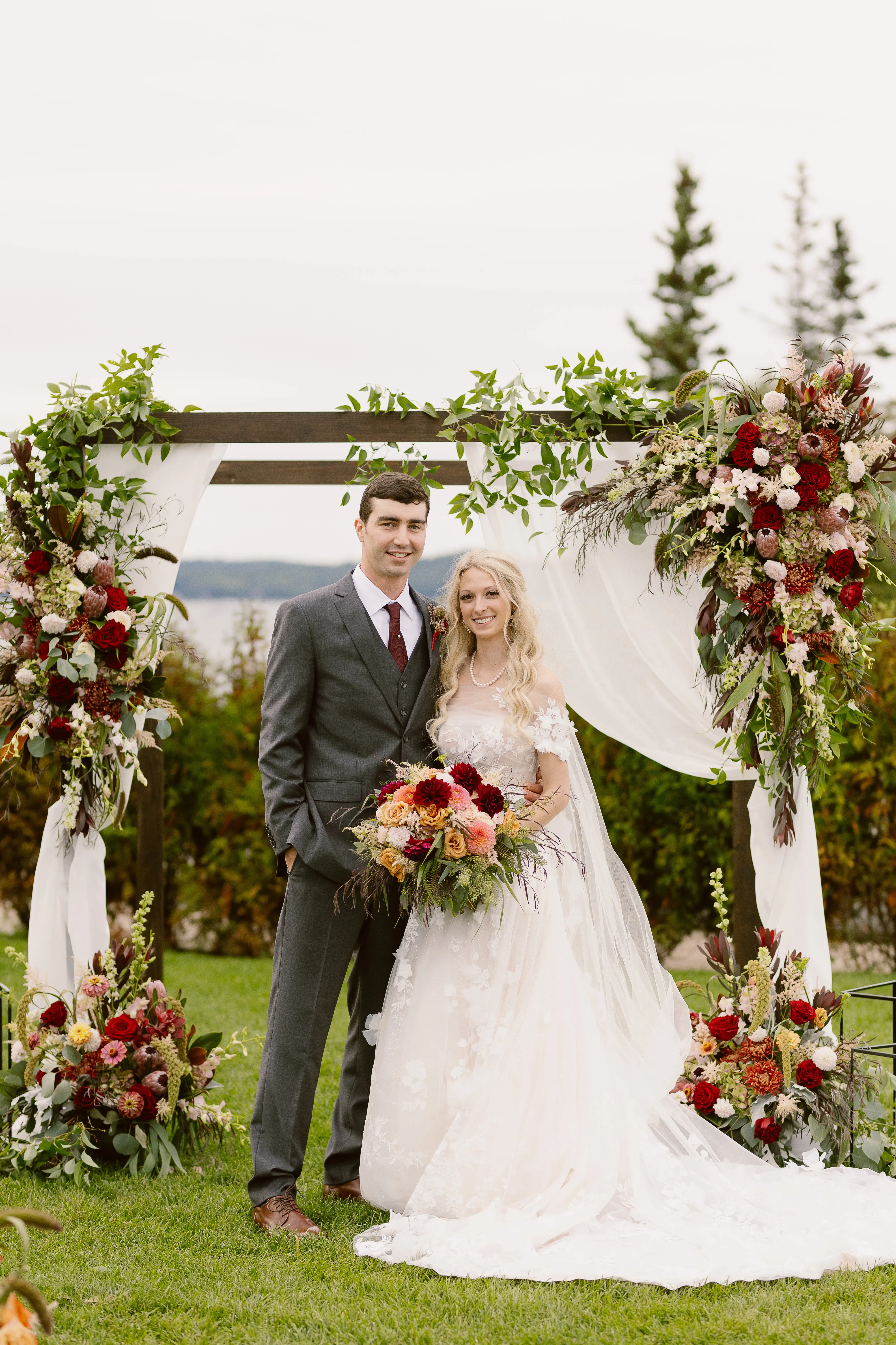Bride wearing Laila wedding dress by Maggie Sottero at the arch with her husband