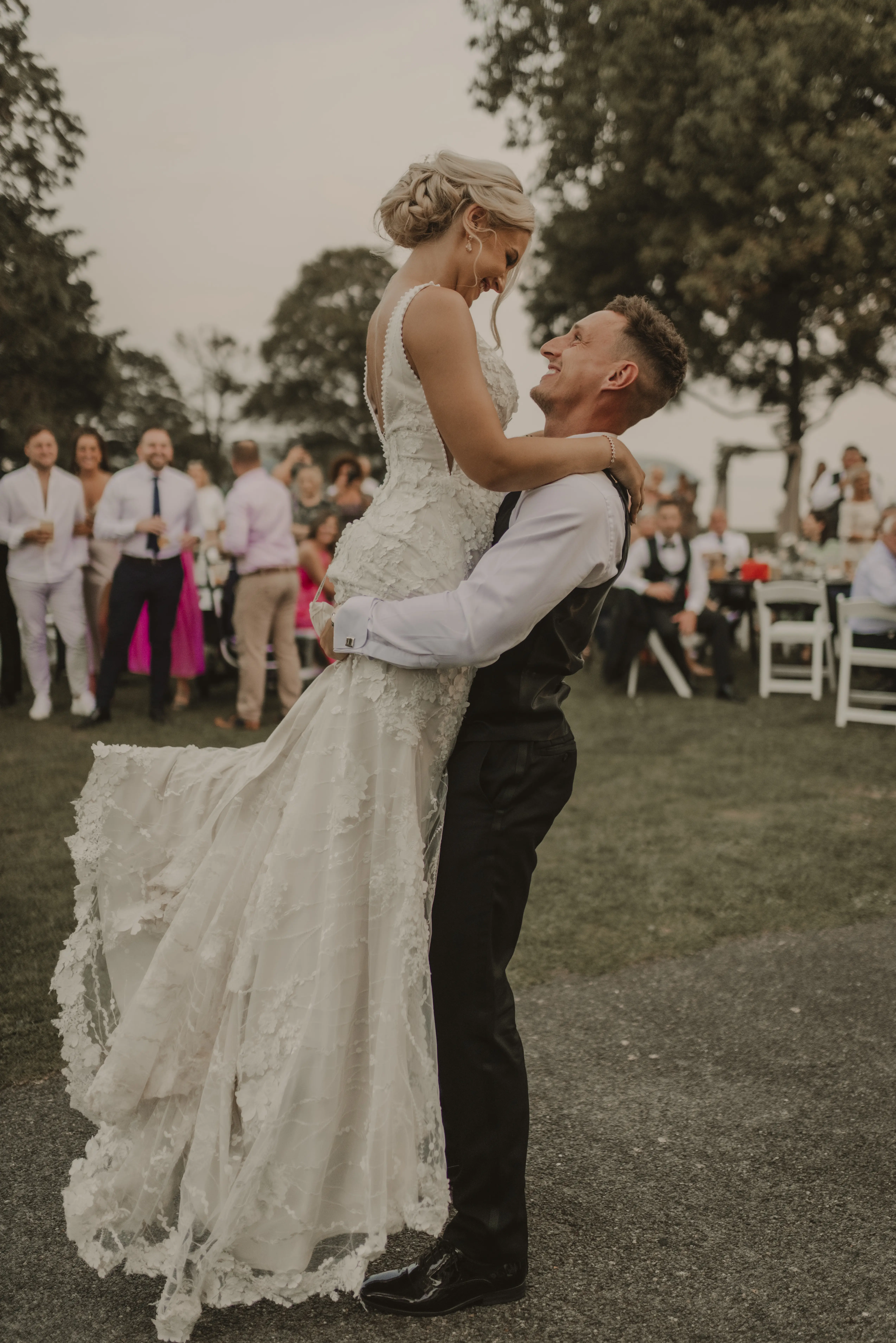 Groom Picks up Bride in Vintage-Inspired Mermaid Wedding Dress with 3-D Floral Motifs and Extended Scalloped Lace Train Called Cruz by Sottero & Midgley