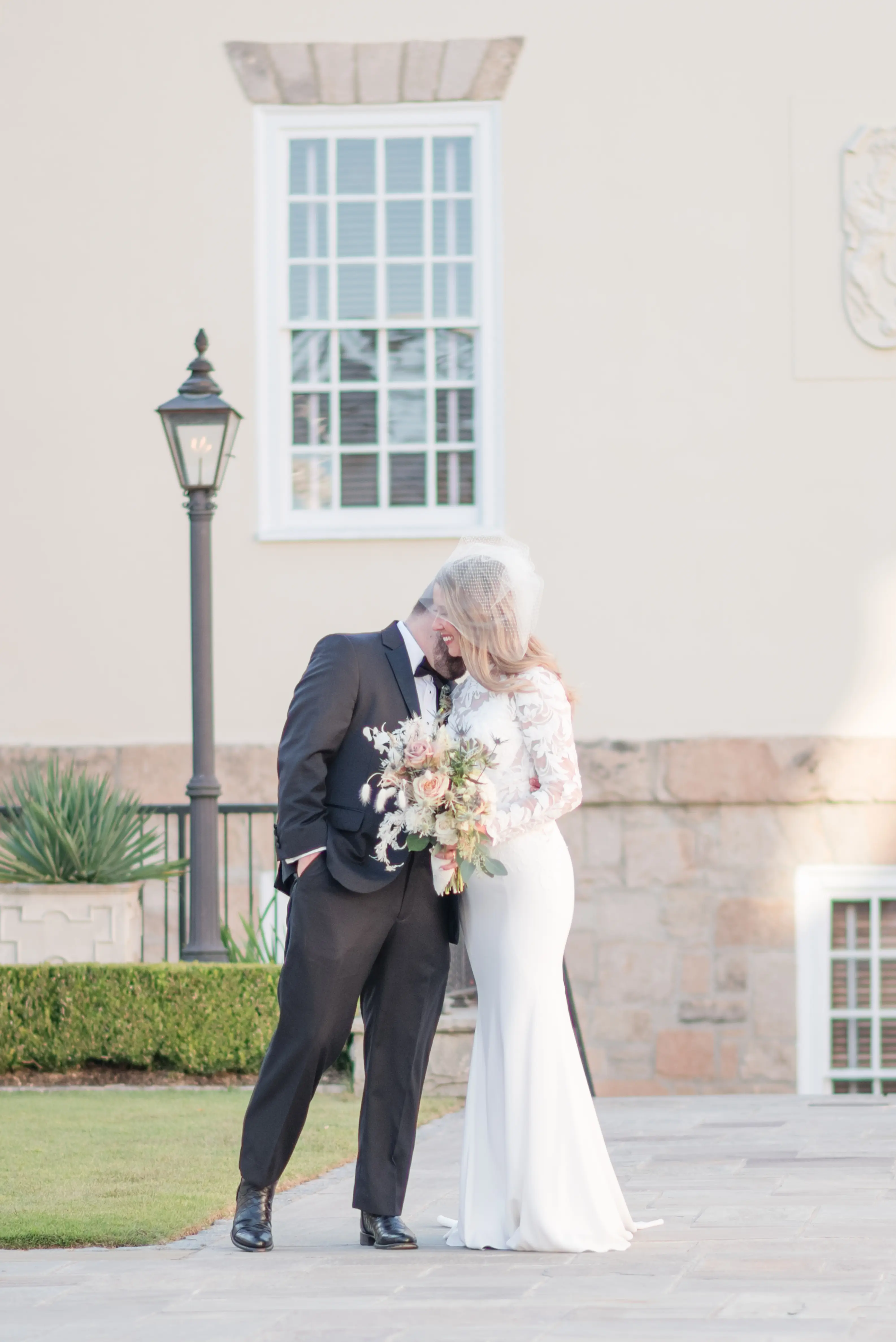 Bride wearing Dionne wedding dress by Rebecca Ingram whispering to her husband