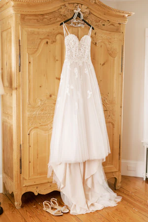 Boho Sheath Wedding Dress Called Marisol By Rebecca Ingram Hanging From An Armoir