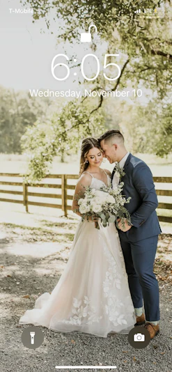 Bride with groom wearing affordable floral ballgown wedding dress.