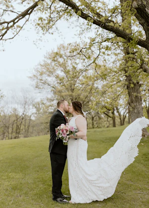 Groom Embracing Bride in Boho Lace Wedding Dress with Oversized Florals Called Burke by Maggie Sottero
