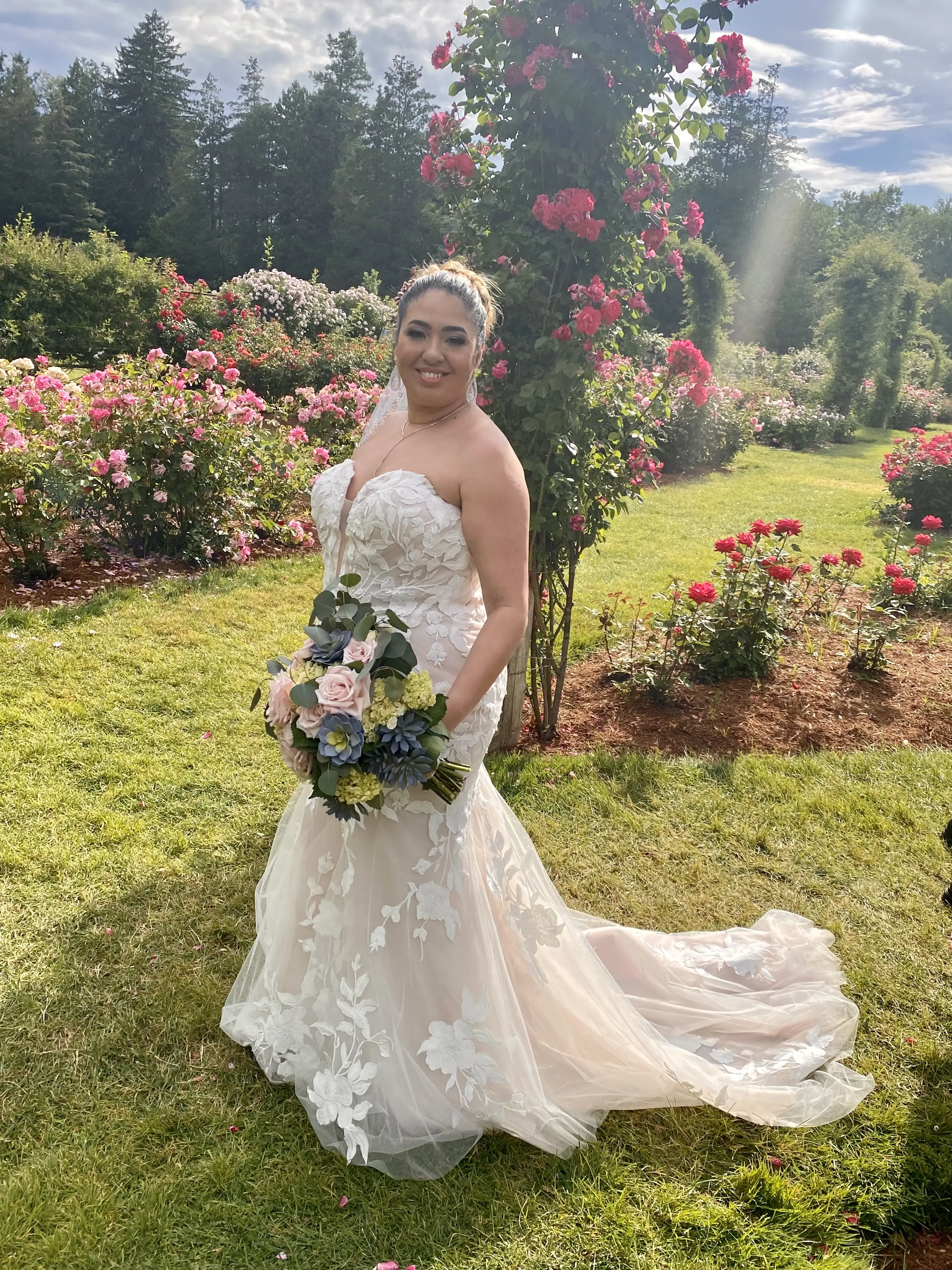 Bride In A Rose Garden Wearing A Strapless Lace Wedding Dress Named Hattie By Rebecca Ingram
