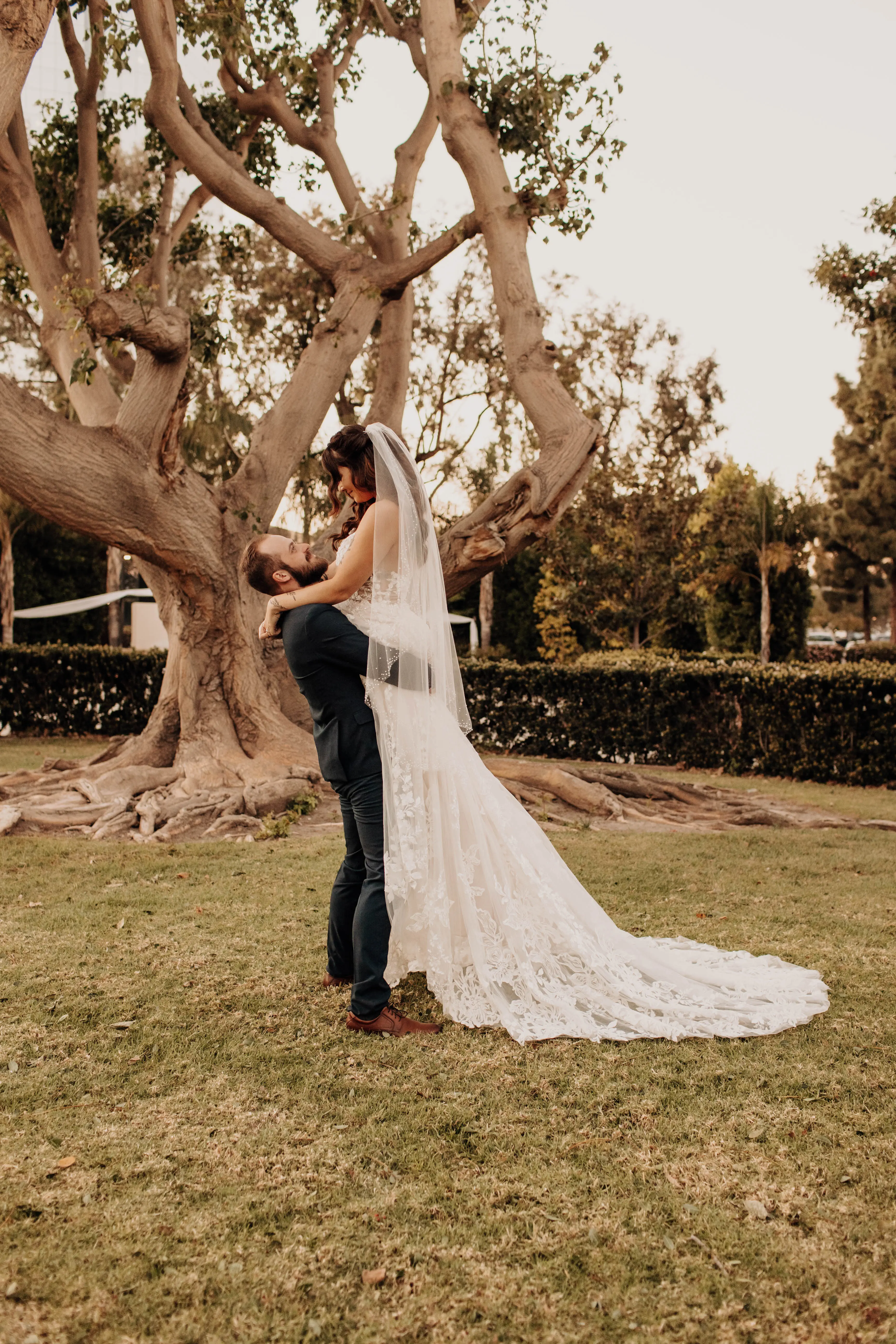 Bride wearing wedding dress called Marlow being lifted up by her groom.