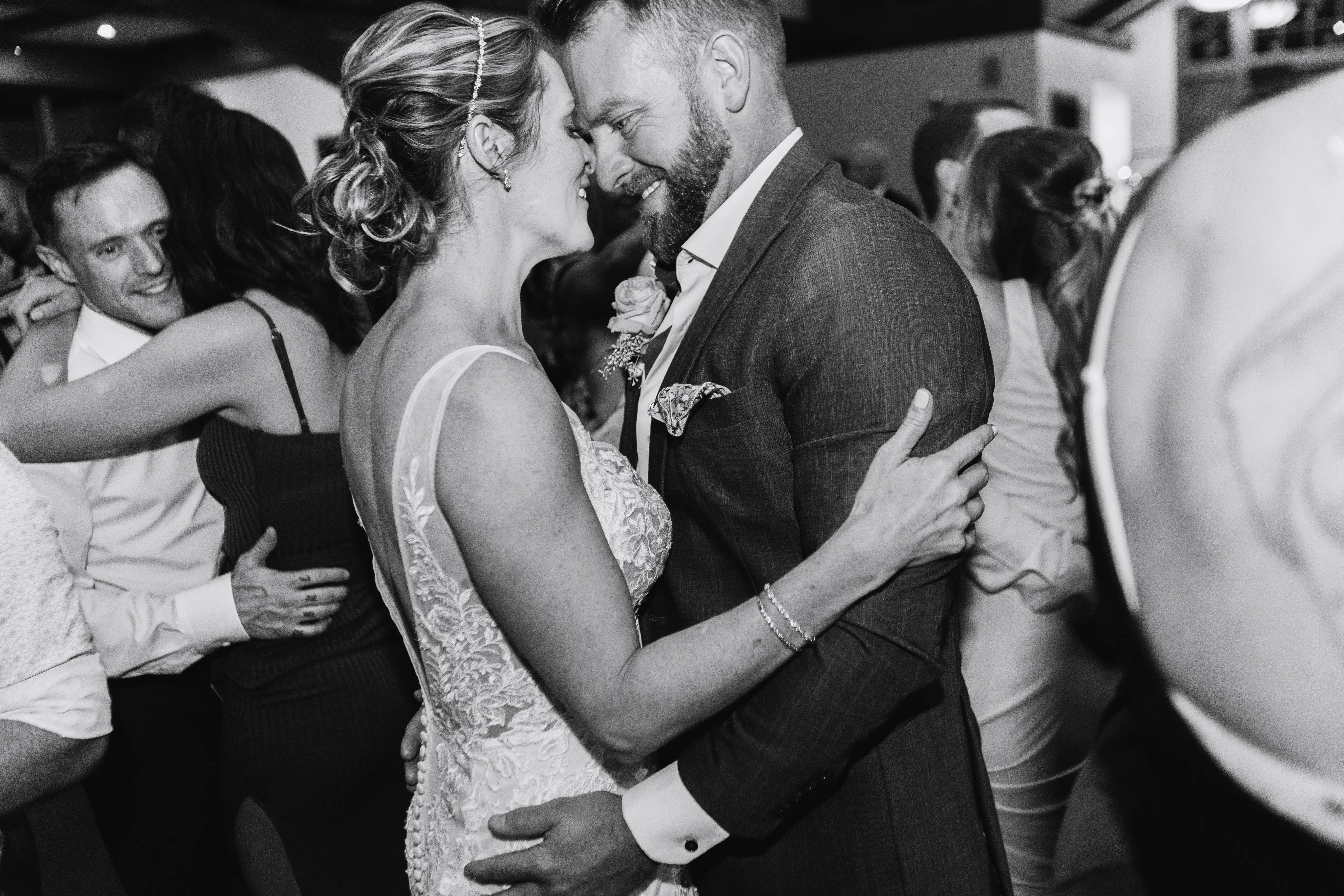 Newlyweds dancing very closely at their reception party.