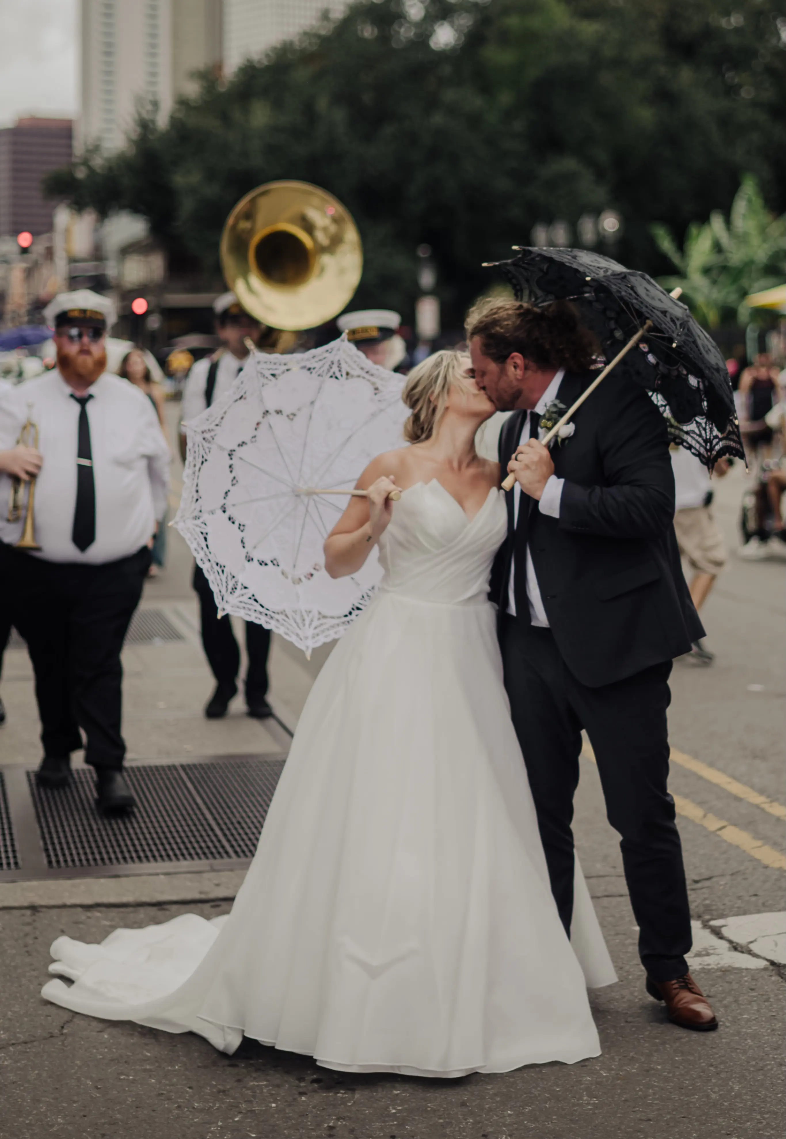 Bride Wearing Modern Princess Wedding Dress Called Aubrielle By Maggie Sottero Kissing Groom With Band Playing Behind Them