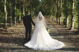 Groom Holding Hands with Bride in Lace Ball Gown Wedding Dress with Sequined Tulle and Lace Motifs over Bodice and Statement Hemline called Tristyn by Maggie Sottero
