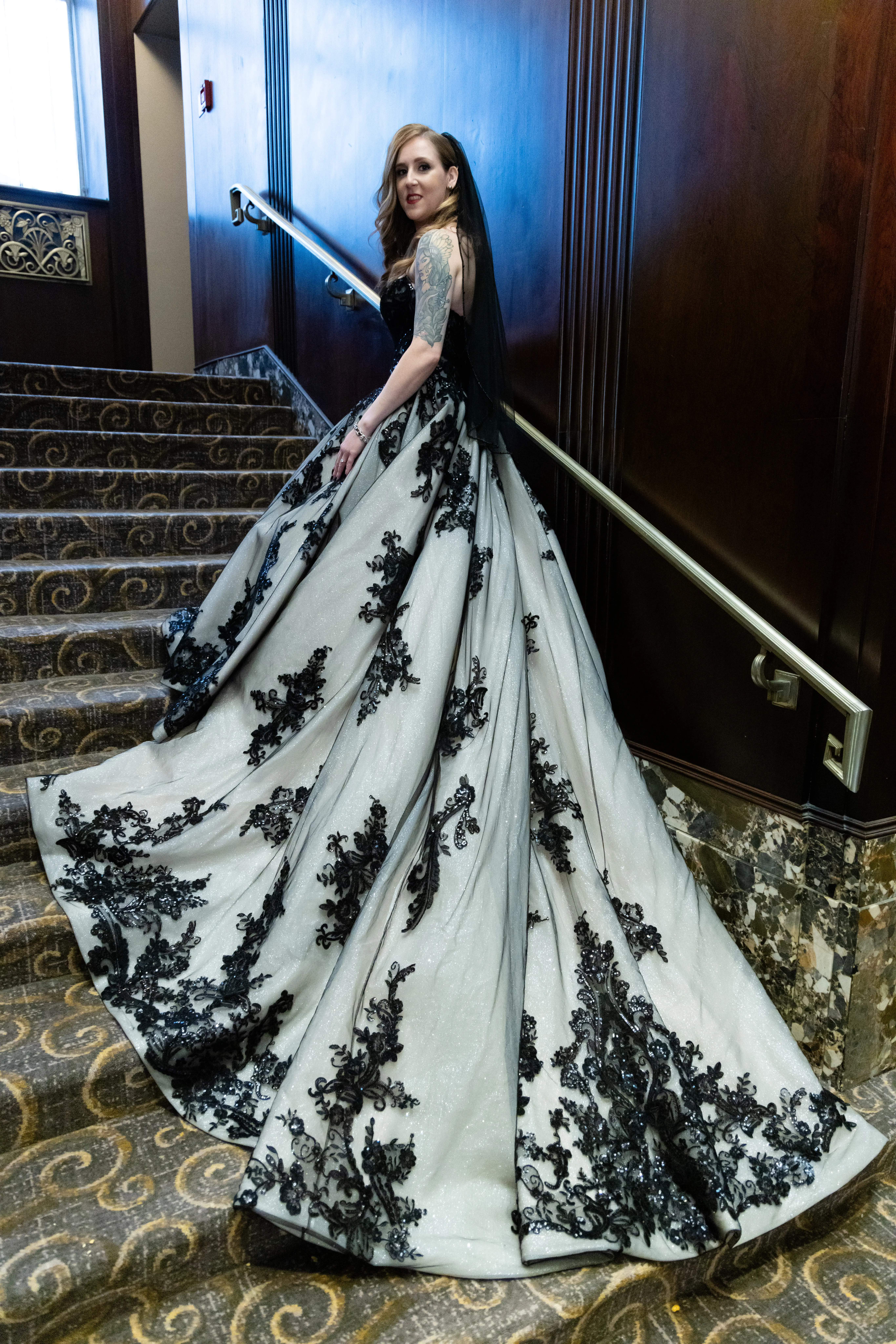 Bride wearing Norvinia wedding dress by Sottero and Midgley walking up the stairs