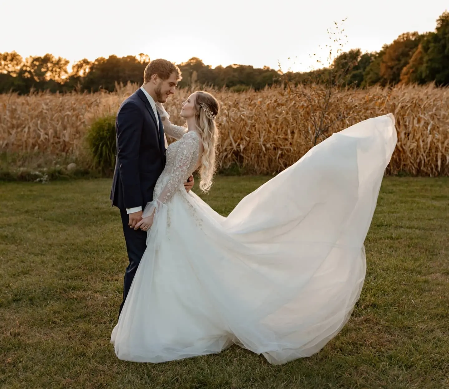 Newlyweds looking into each other's eyes while the train of the bride's dress floats in the air.