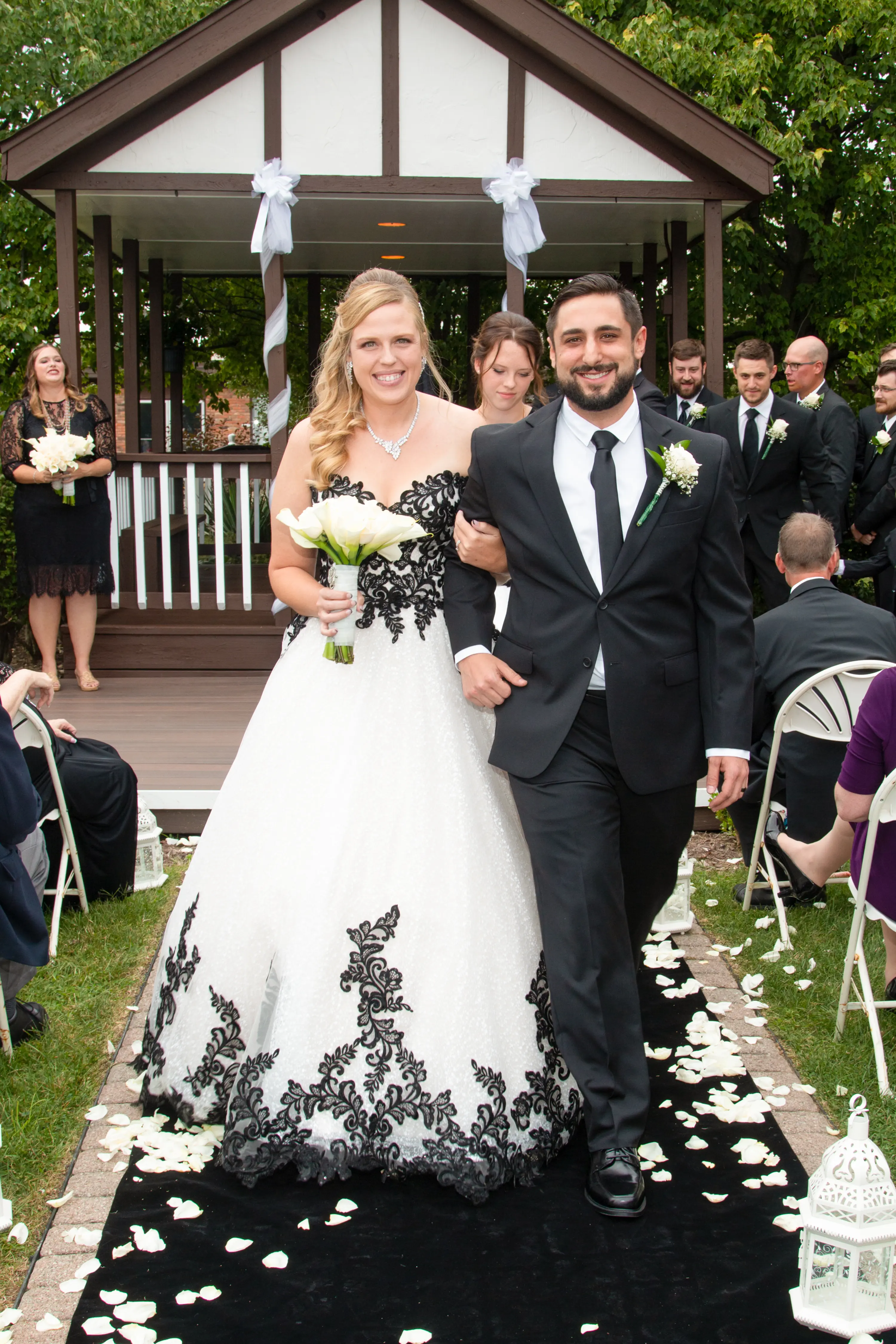 Bride Wearing A-Line Black Lace Wedding Dress Called Tristyn By Maggie Sottero Walking With The Groom