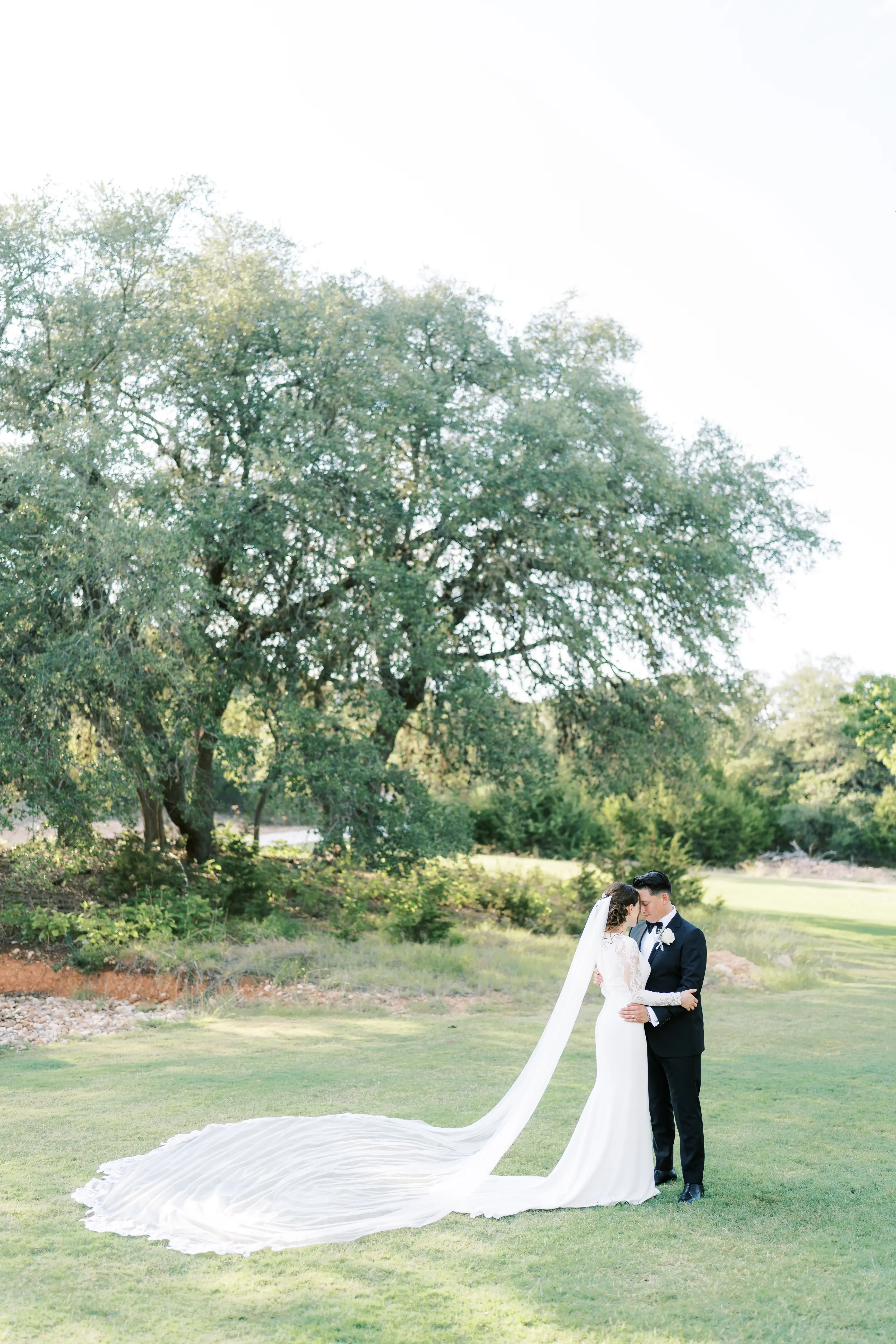 Bride Wearing Simple Long Sleeve Wedding Dress Called Bethany By Rebecca Ingram With A Very Long Veil