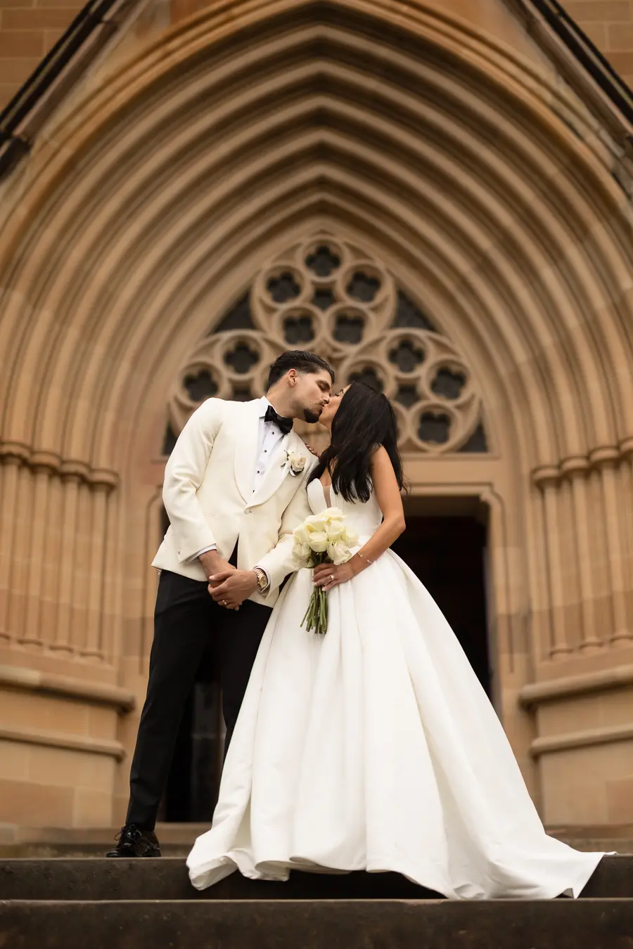 Bride wearing Derrick by Maggie Sottero kissing her husband