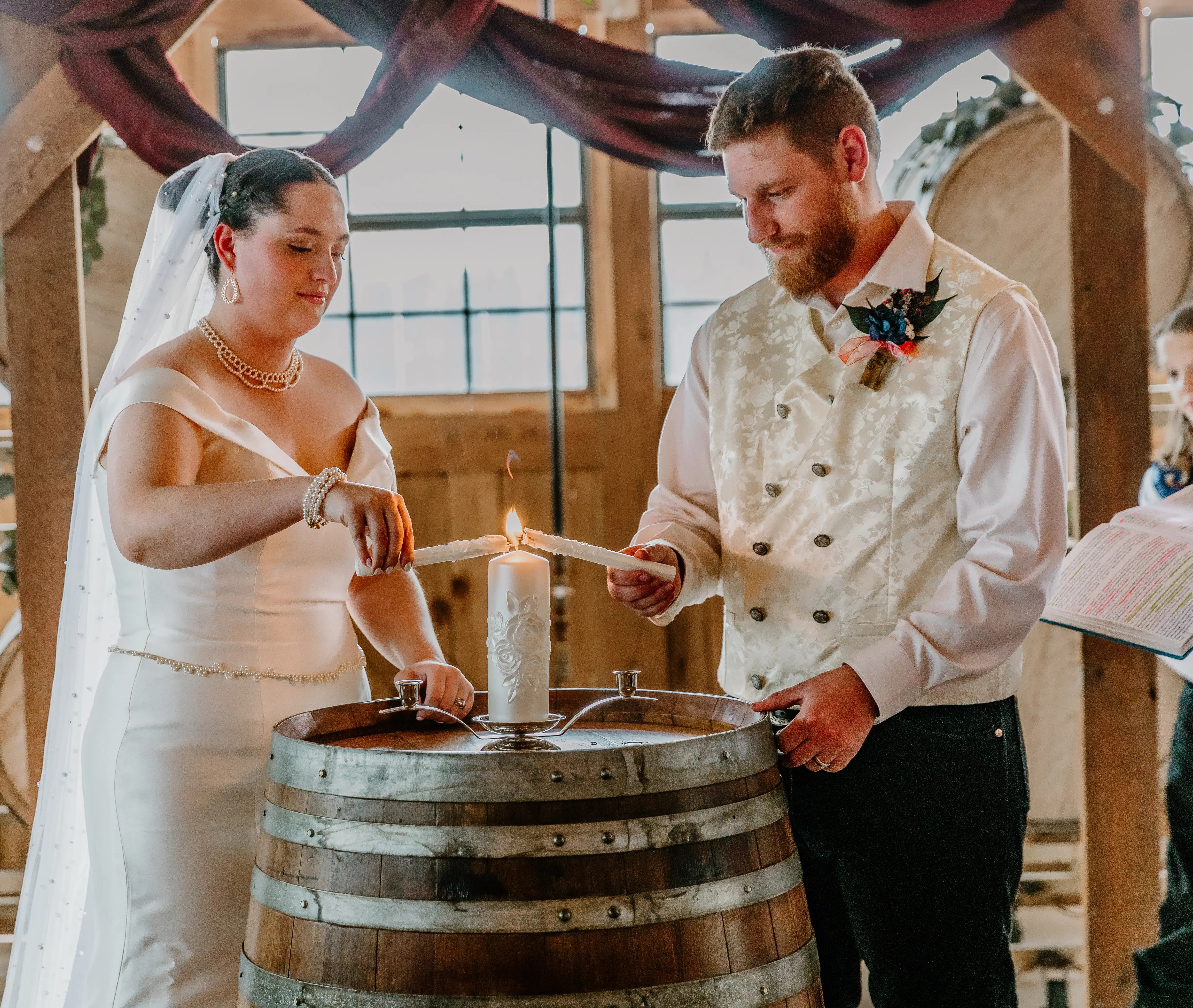 Bride Wearing Simple Fit And Flare Wedding Dress Called Josie By Rebecca Ingram Lighting A Candle With Groom