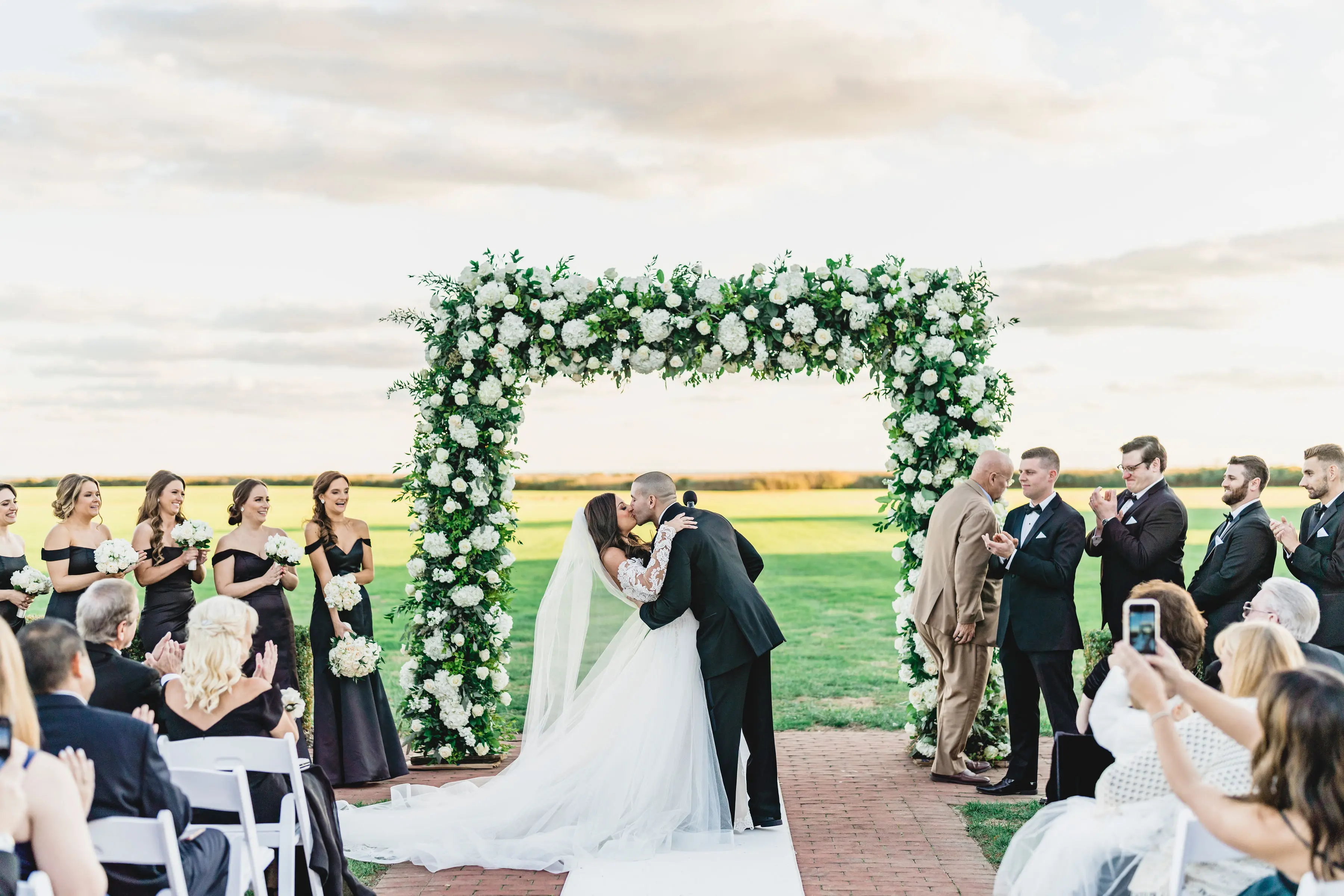 Bride Wearing Sparkly Lace Fit-and-Flare Wedding Dress Kissing Groom.