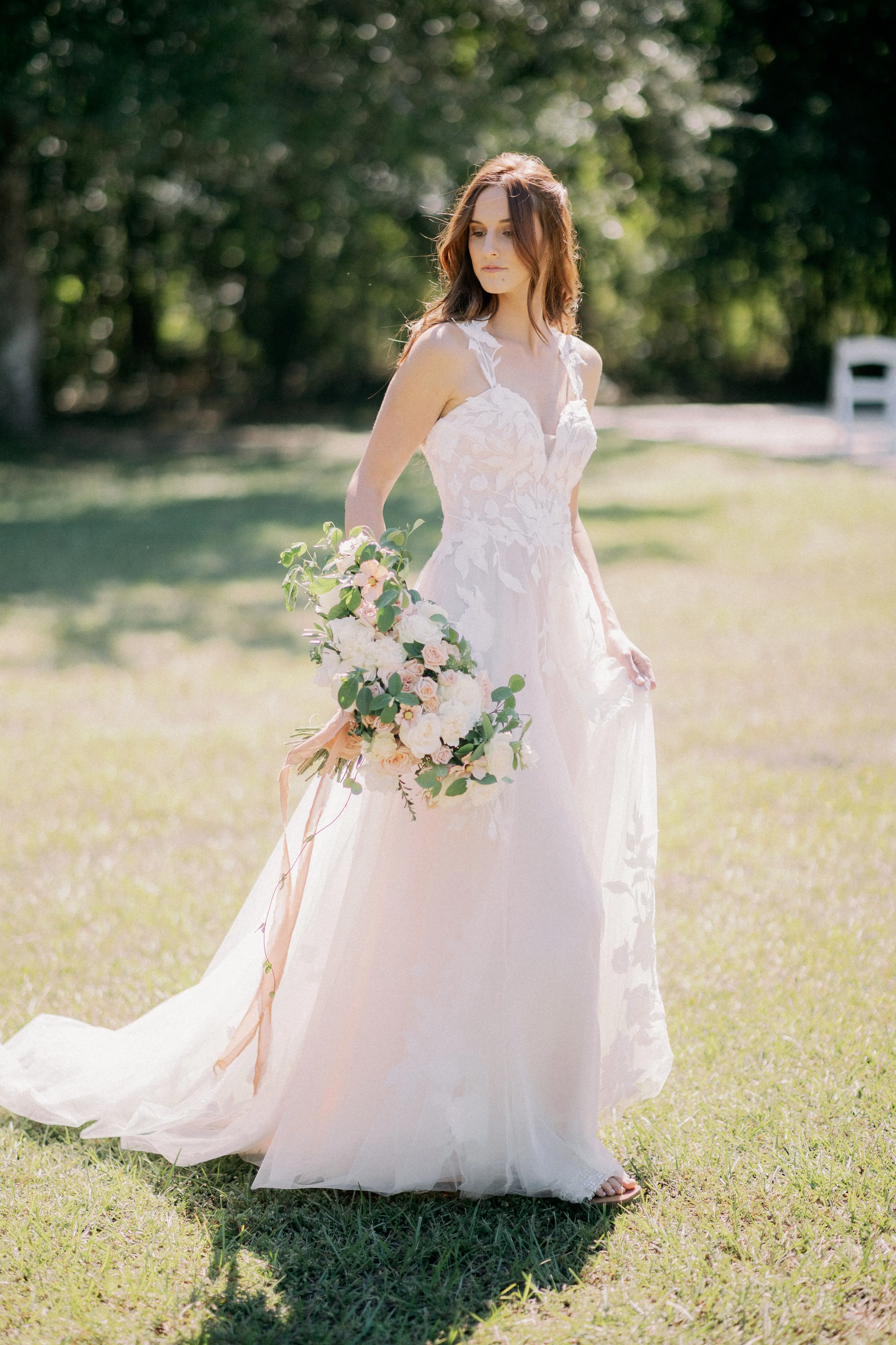 Bride Wearing Plunging V-Neckline Bridal Dress Named Hattie Lane Marie By Rebecca Ingram Bride In Grass Field